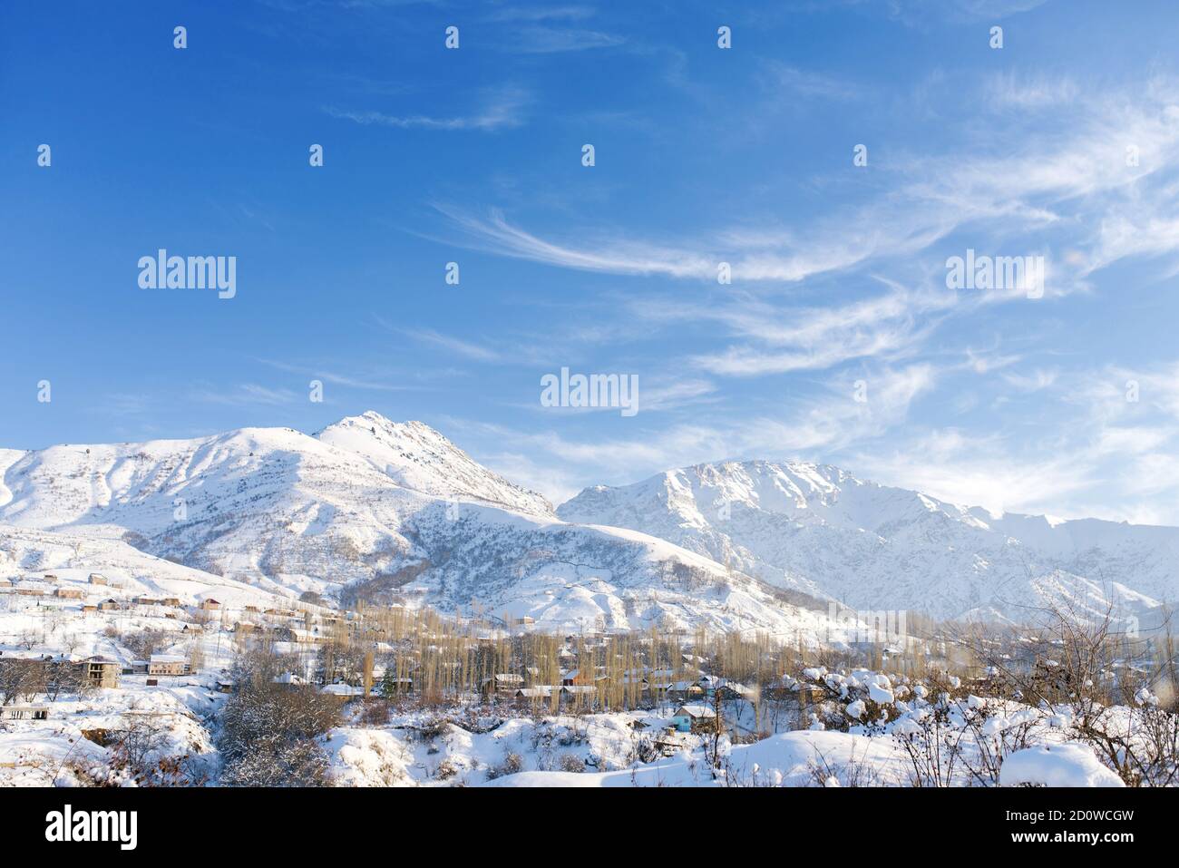 Erstaunliche Winterlandschaft der Berge in Usbekistan im Winter. tien shan. Blauer schöner Himmel und leichte Wolken darauf Stockfoto