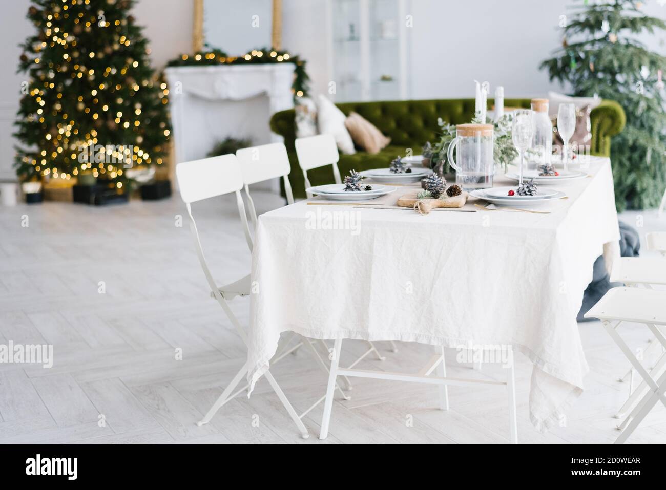 Ein gemütlicher Ort mit Weihnachtsschmuck, einem Weihnachtsbaum und einem guten Tisch für eine große Familie. Weihnachten oder Neujahr Interieur. Stockfoto