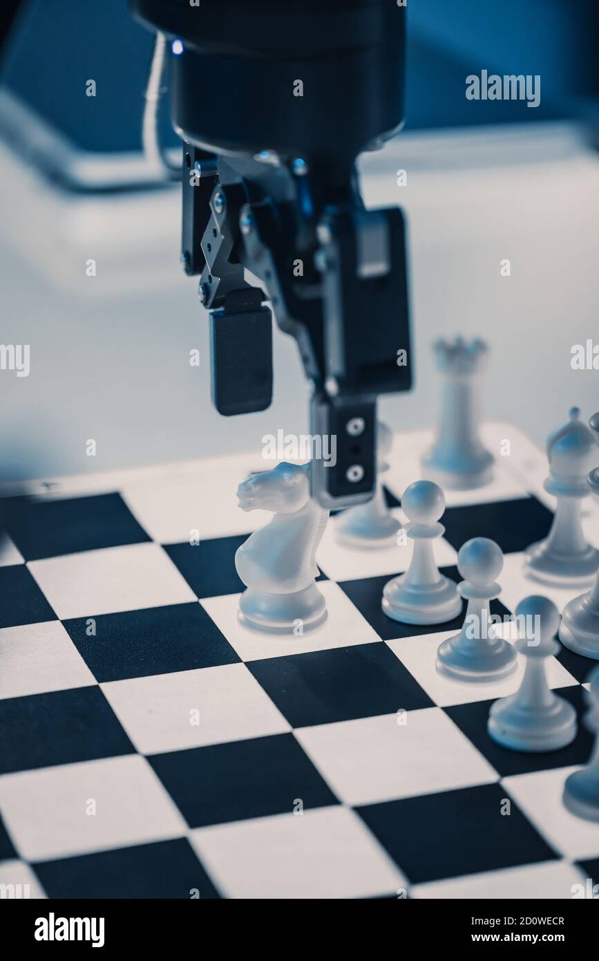 Nahaufnahme Vertikale Aufnahme von künstlicher Intelligenz Einen futuristischen Roboterarm in einem Schachspiel gegen einen Menschen operieren. Roboter bewegt einen Bauer. Sie sind es Stockfoto