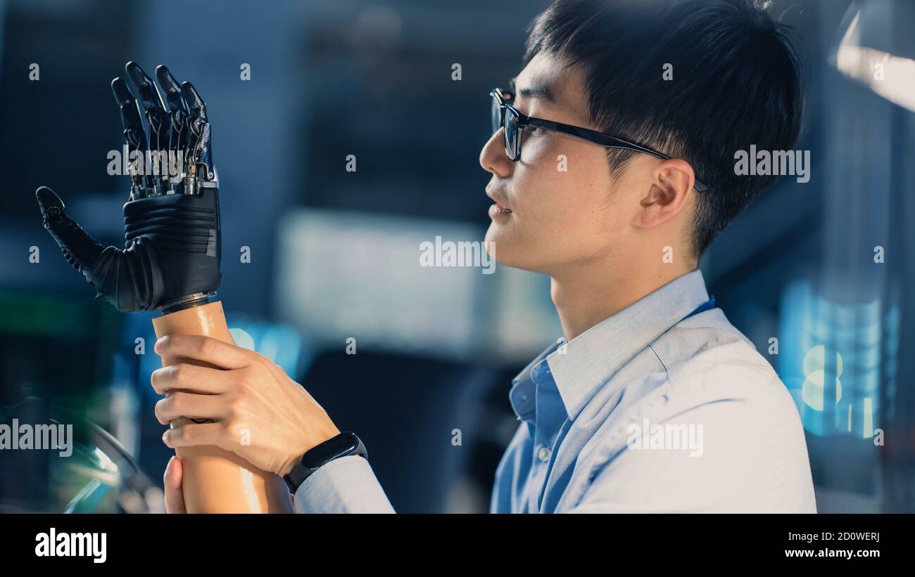 Nahaufnahme eines futuristischen prothetischen Roboterarms, der getestet wird Von einem professionellen japanischen Entwicklungsingenieur in einem High Tech Forschungslabor mit Stockfoto