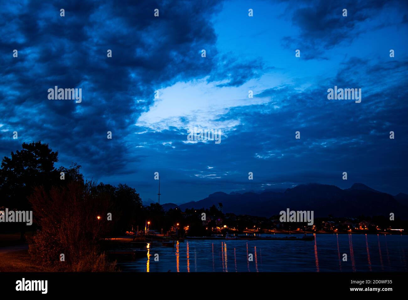 Sonnenuntergang und blaue Stunde mit einem wolkigen blauen Himmel an Der See und die Berge Stockfoto