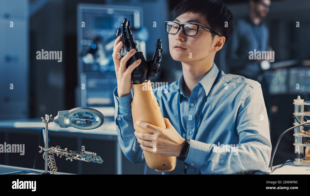 Futuristischer prothetischer Roboterarm, der von einem professionellen Japaner getestet wird Entwicklungsingenieur in einem High-Tech-Forschungslabor mit modernen Computer Stockfoto