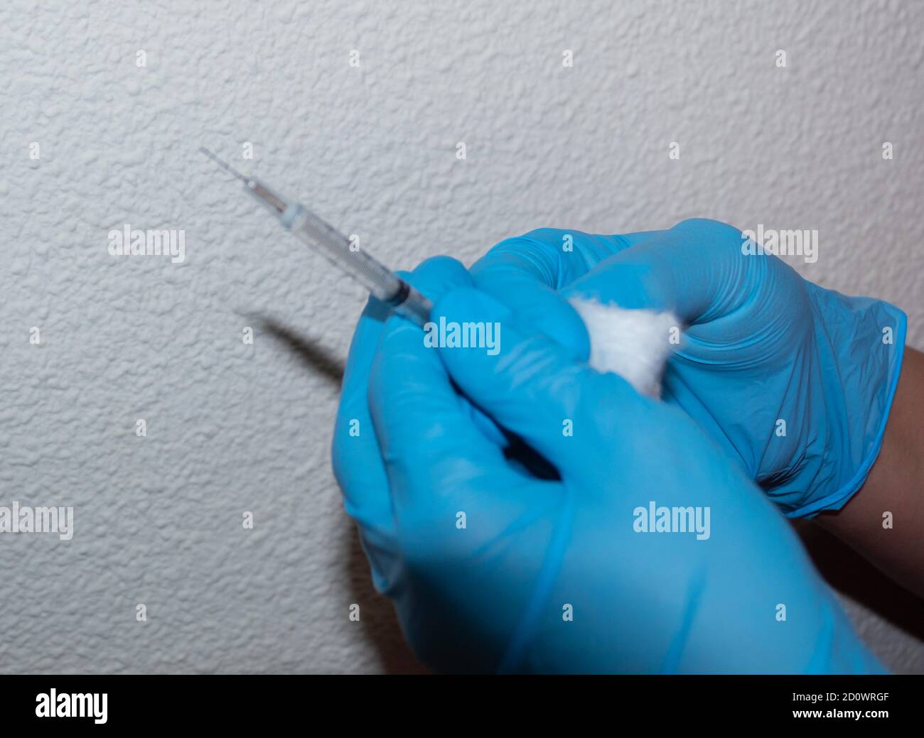 Halten der blauen medizinischen Handschuhe der Allergie oder Covid19 Grippe-Impfstoffspritze Stockfoto