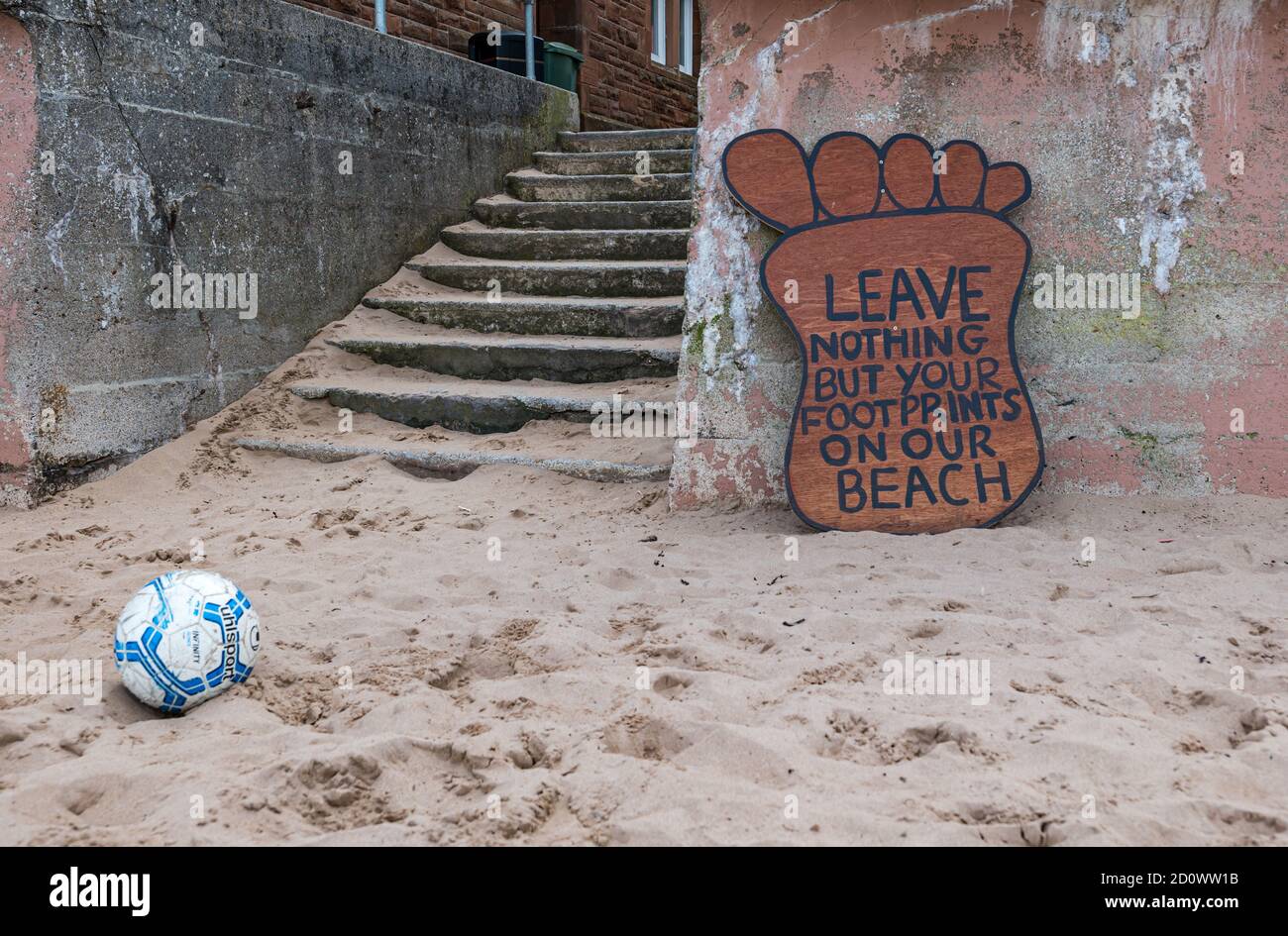 Schrullige Fußabdruck Hinweis fordert Besucher zu halten den Strand sauber mit einem streunenden Fußball, North Berwick, East Lothian, Schottland, Großbritannien Stockfoto