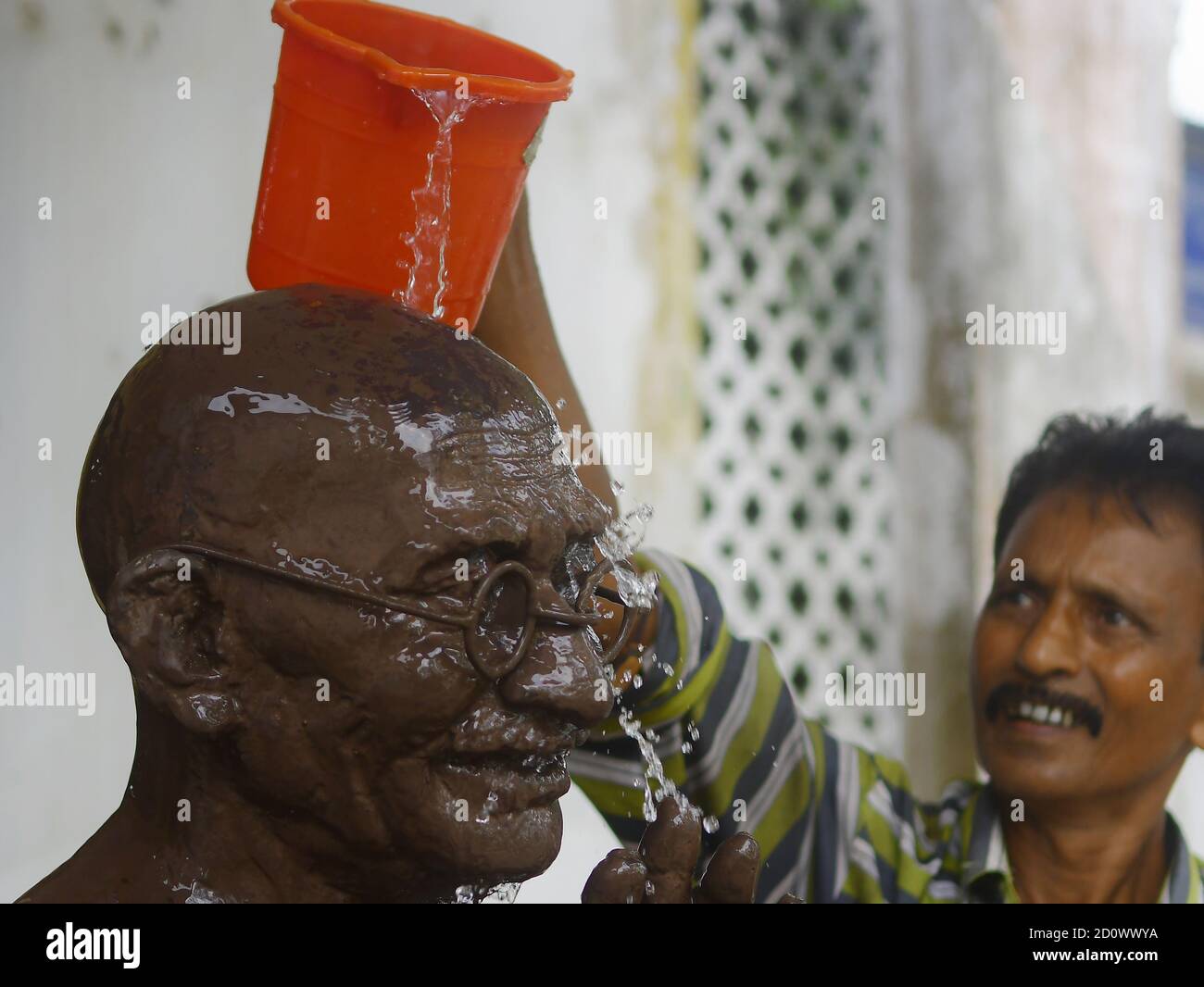 Ein Arbeiter wäscht und putzt die Statue von Mahatma Gandhi am Vorabend seines Geburtstages in Agartala. Tripura, Indien. Mahatma Gandhi war ein indischer Anwalt, antikolonialer Nationalist und politischer Ethiker, der gewaltfreien Widerstand einstellte, um die erfolgreiche Kampagne für Indiens Unabhängigkeit von der britischen Herrschaft zu führen, und wiederum Bewegungen für Bürgerrechte und Freiheit auf der ganzen Welt inspirierte. Stockfoto
