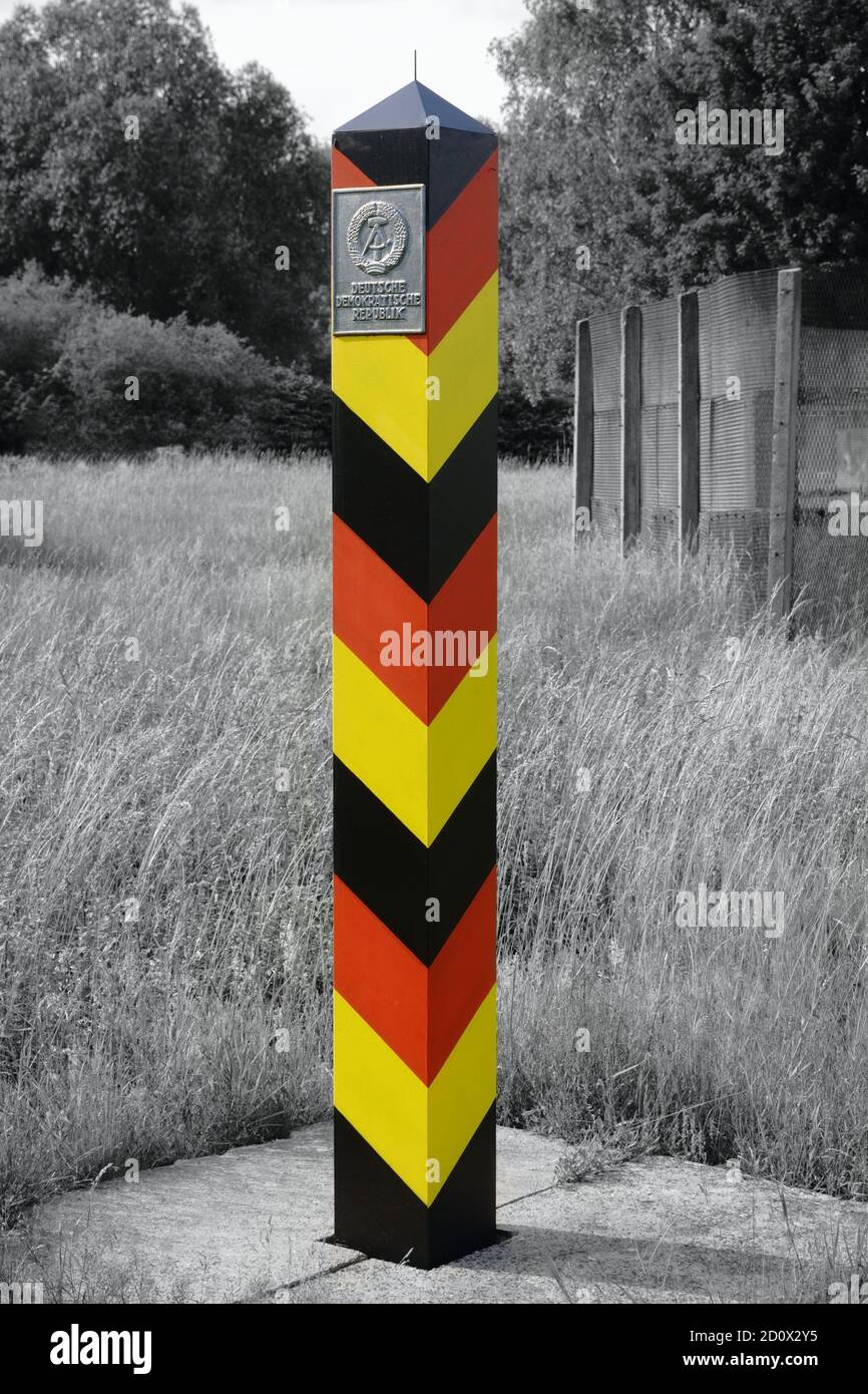 Historische DDR (DDR, DDR) Grenzsäule. Ehemalige innerdeutsche Grenze. Im Hintergrund der Grenzzaun. Stockfoto