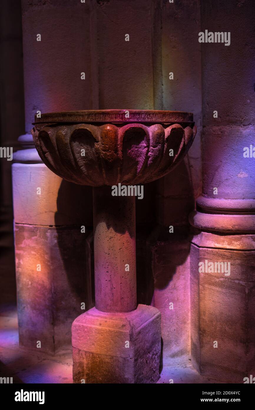 Kupfervase für heiliges Wasser in der Kirche. Schöne Farben auf der Steinwand Hintergrund. Katholische Religion Stockfoto