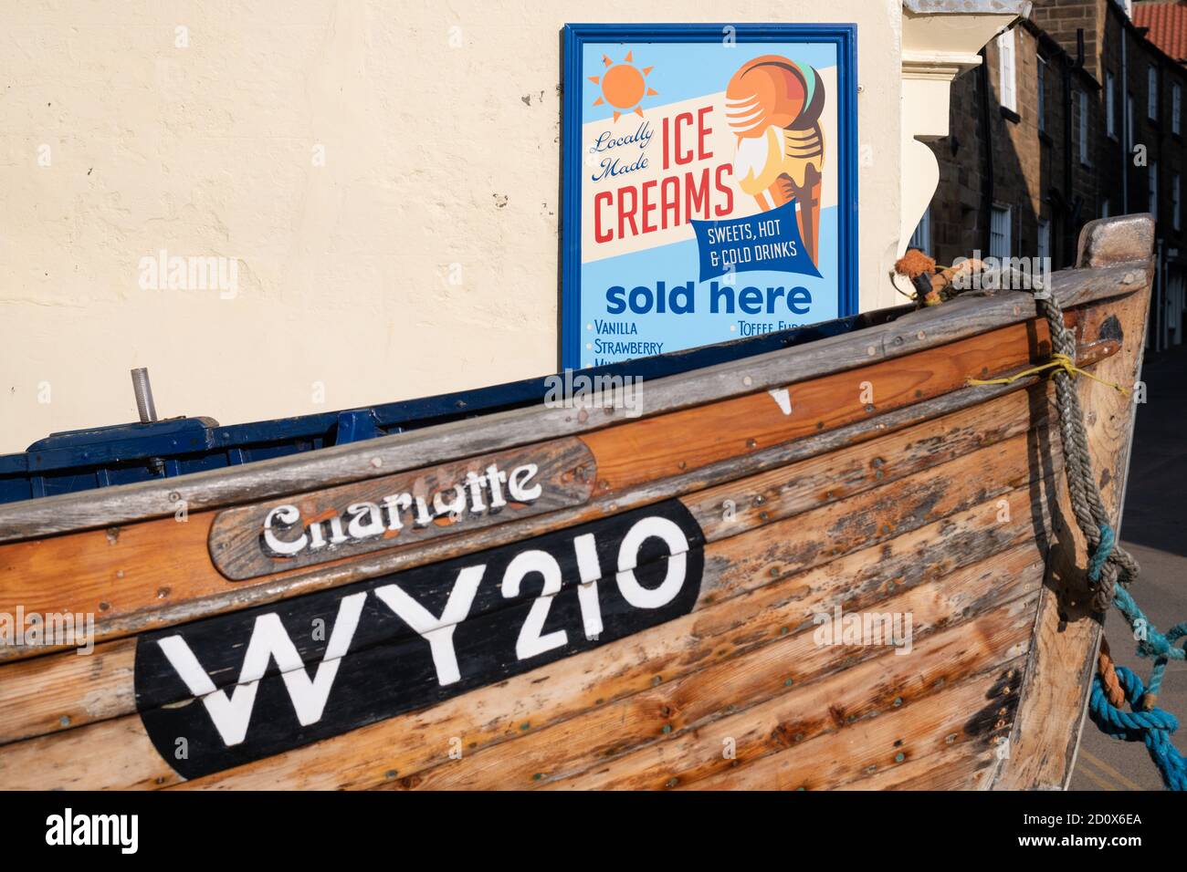 Robin Hoods Bay, North Yorkshire, England, UK - Schalentier Boot und Eis Werbung Zeichen Stockfoto