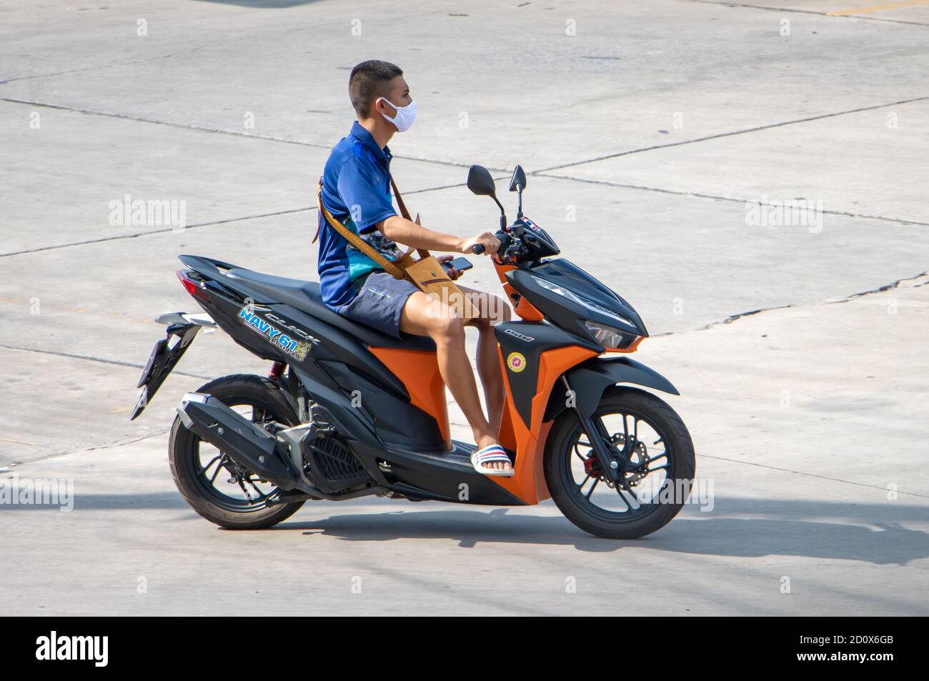 SAMUT PRAKAN, THAILAND, JULI 29 2020, EIN Mann mit Gesichtsmaske fährt ein Motorrad Stockfoto