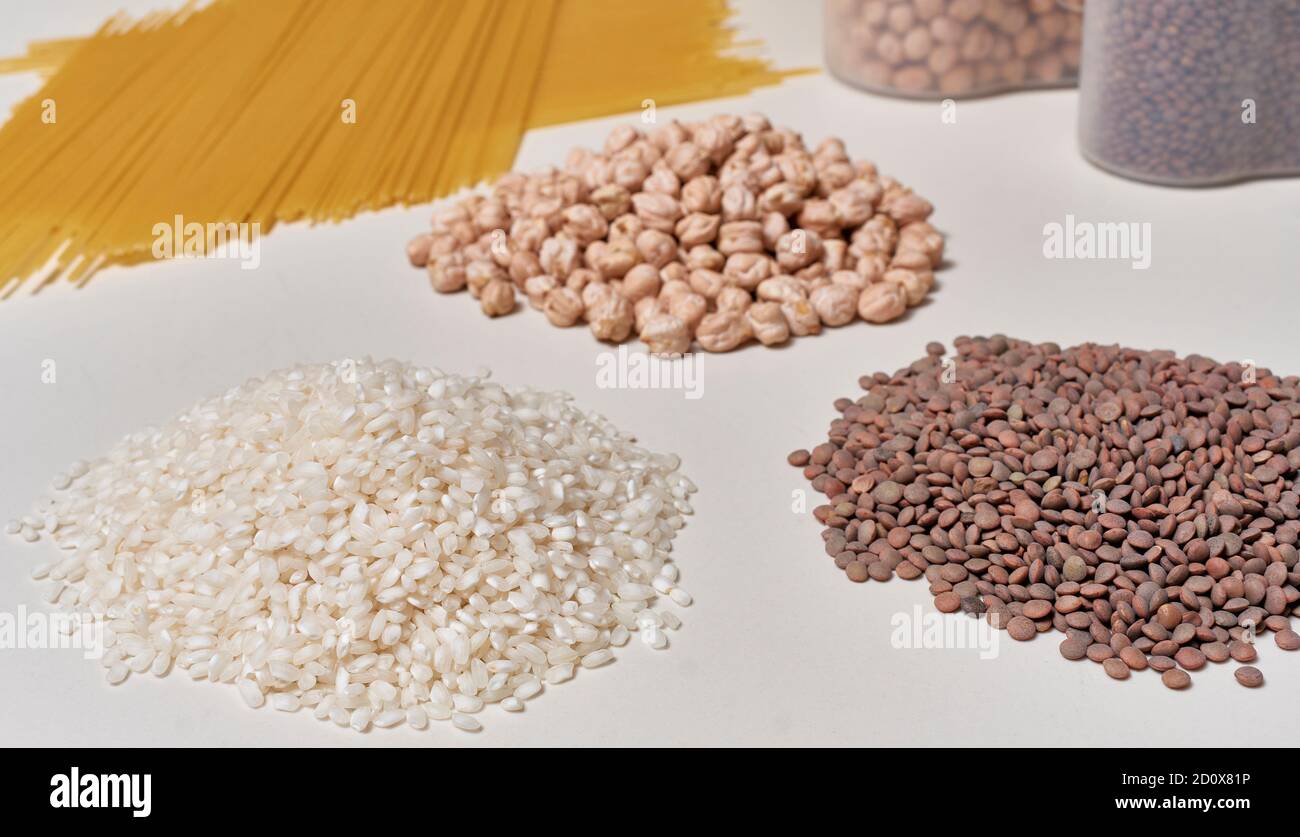 Reis, Linsen, Kichererbsen und Nudeln. Grundlegende rohe Lebensmittel mit Kohlenhydraten für eine gesunde und ausgewogene Ernährung Stockfoto