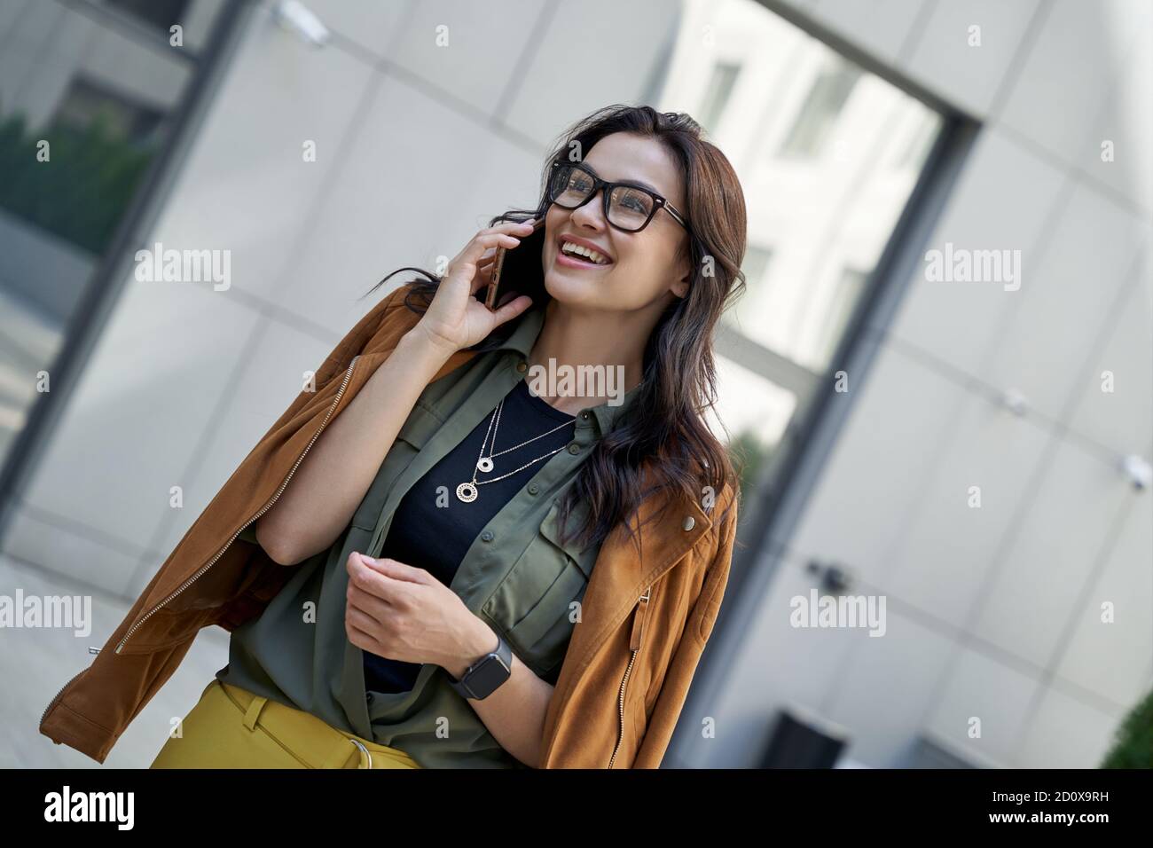 Nette Gespräche genießen. Junge schöne und stilvolle Frau im Gespräch auf dem Smartphone mit Freund und lächelnd, während Sie auf der Straße der Stadt. Urban Lifestyle Konzept, Menschen Stockfoto