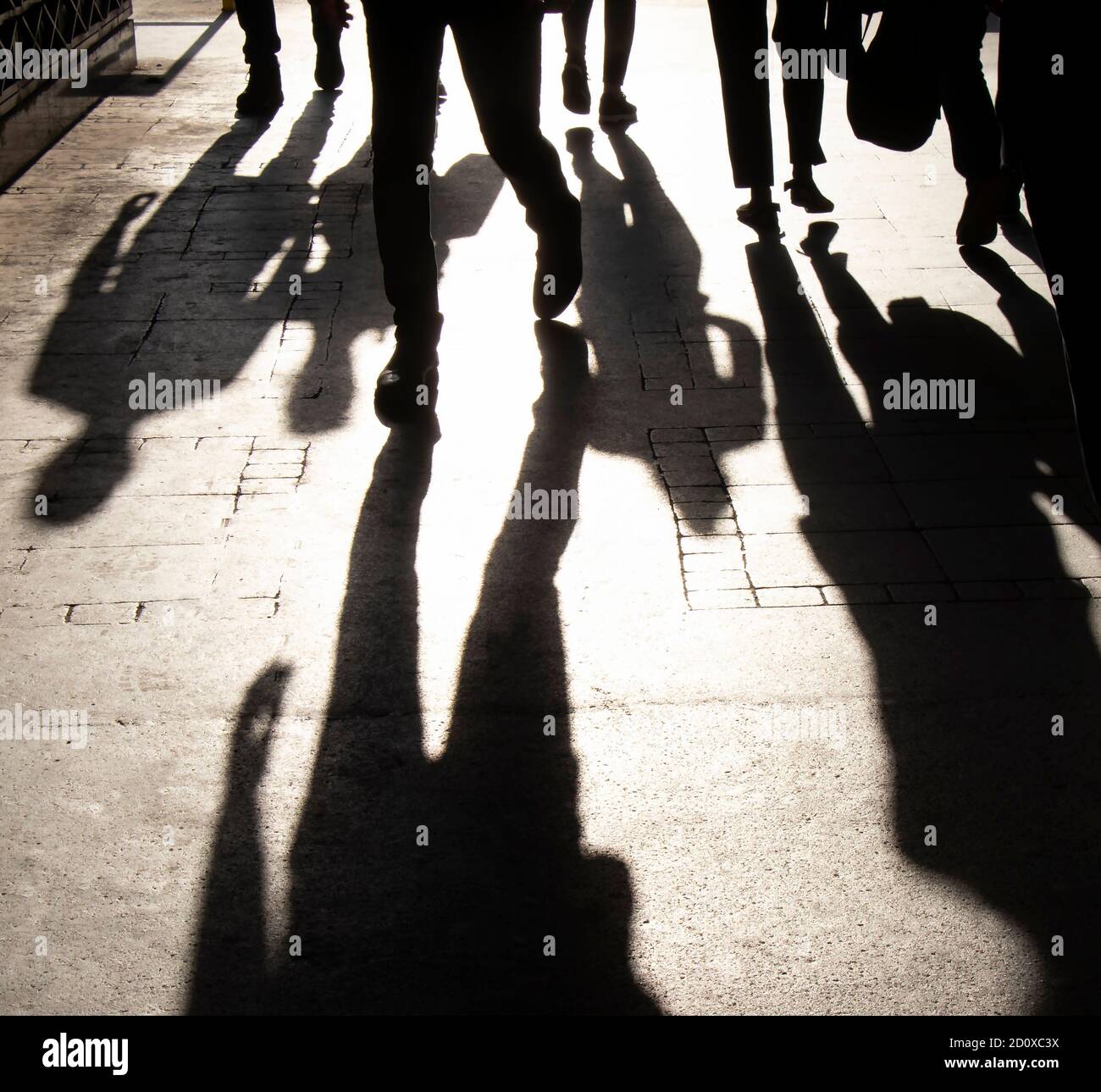 Verschwommene Schattensilhouette von Menschen, die eine belebte Fußgängerzone erreichen Sepia schwarz und weiß mit hohem Kontrast Stockfoto