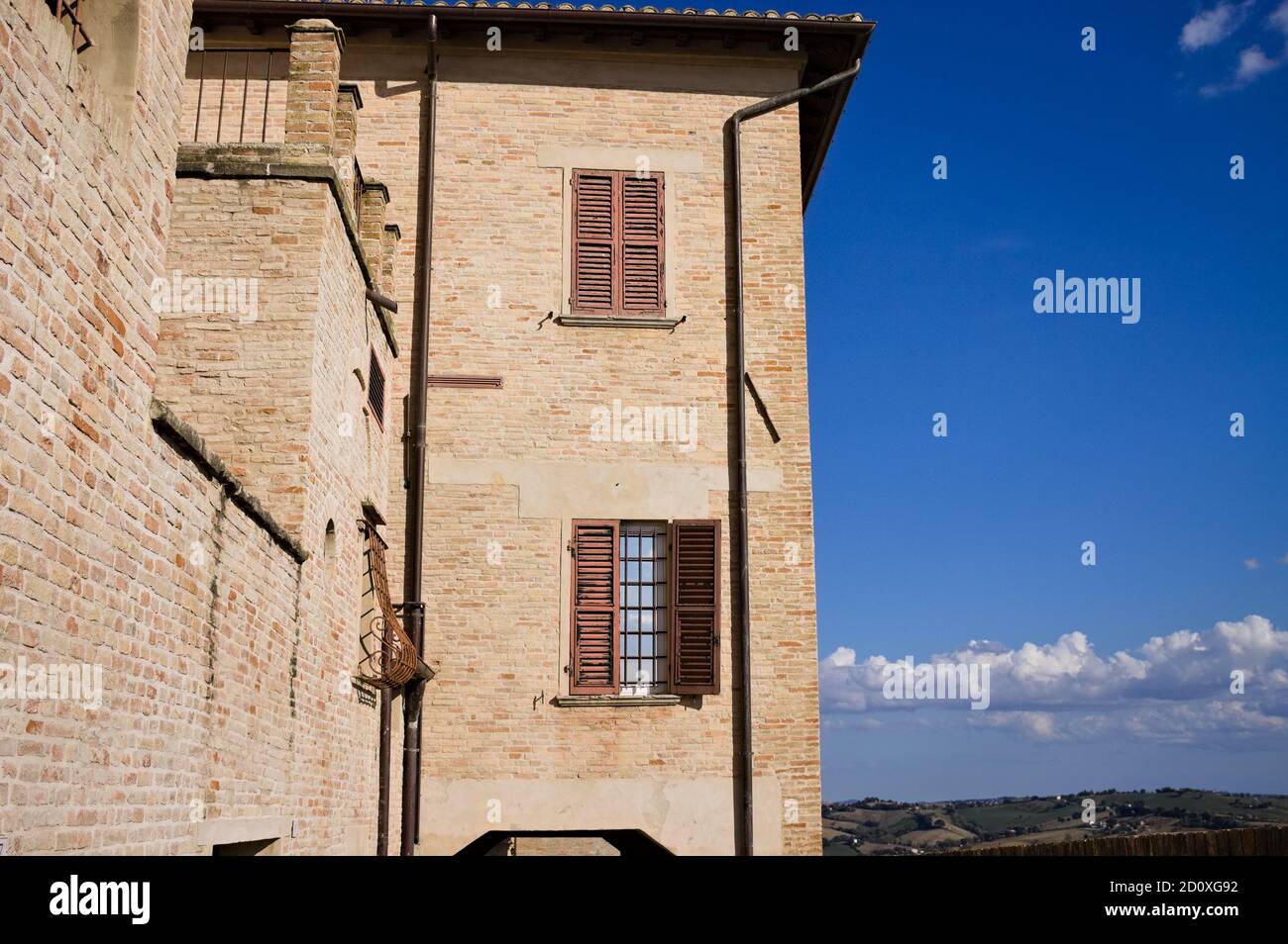 Ein altes Backsteingebäude mit braunen Fenstern und Panoramablick im Hintergrund (Corinaldo, Marken, Italien, Europa) Stockfoto