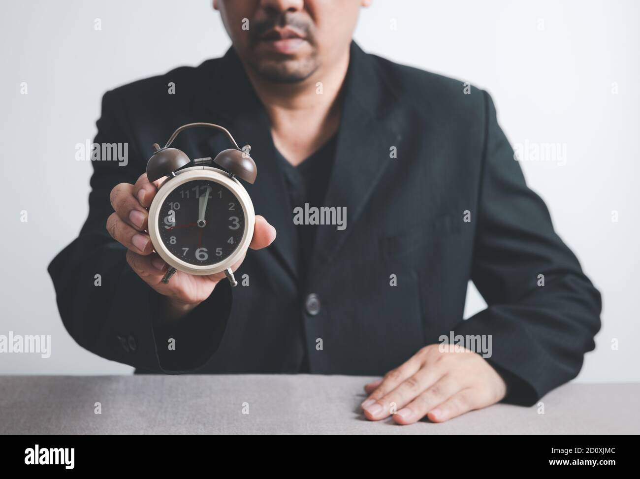 Geschäftsmann hält einen Timer-Alarm auf weißem Hintergrund, Zeitmanagement starten Geschäftskonzept, Stockfoto