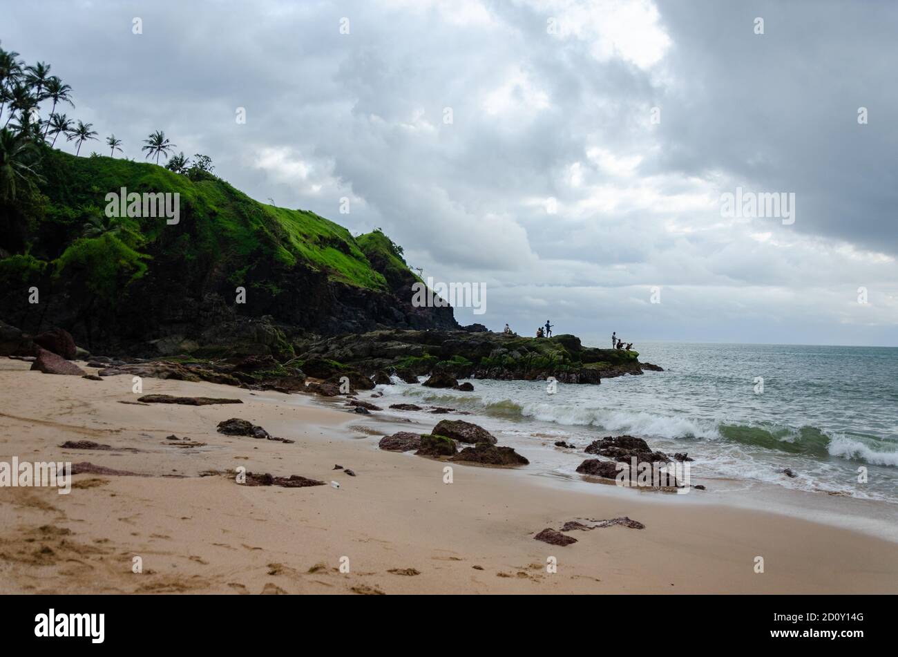 Fischer fischen weit weg, stehen auf Felsen am Kakolem Beach, Canacona, Goa, Indien Stockfoto