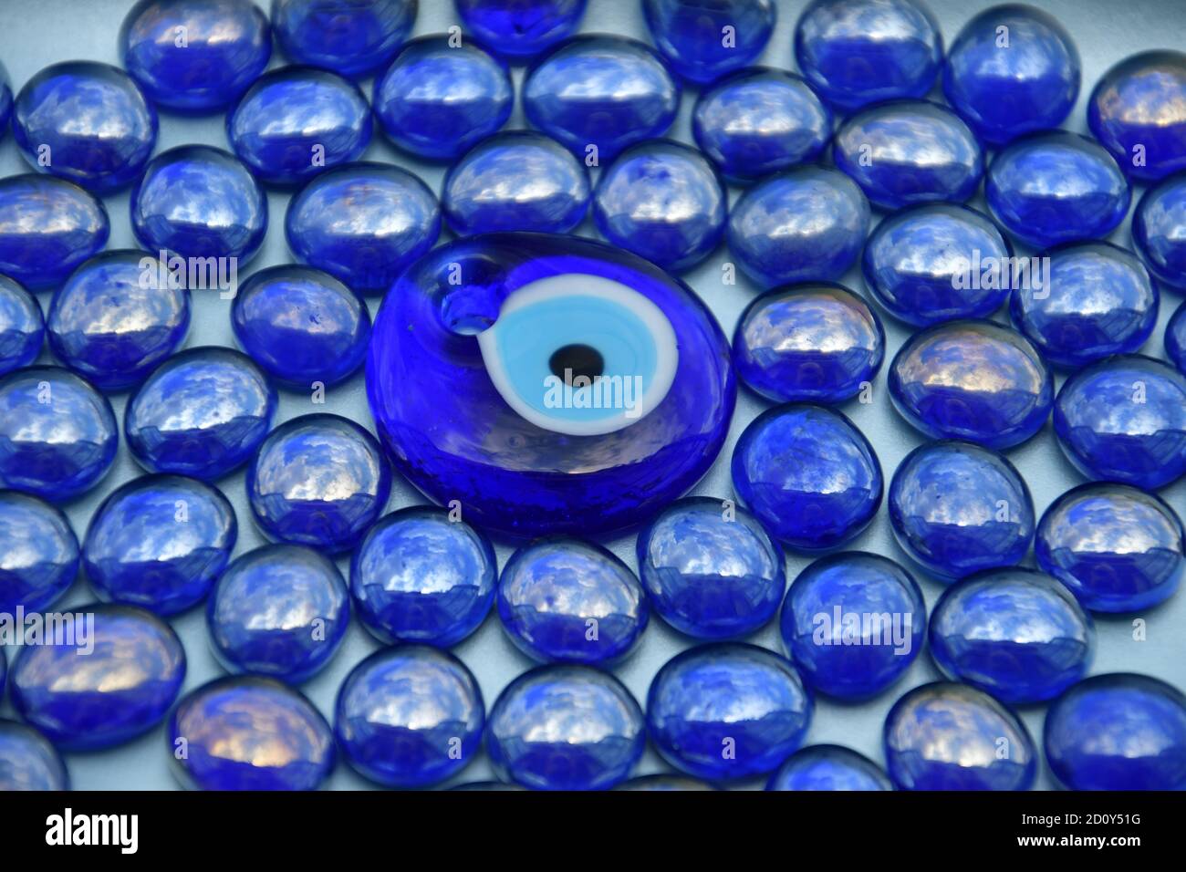 Eine Vogelperspektive von glänzenden irriabent blauen Glasperlen mit einem zentralen Pfau Design Perle. Stockfoto
