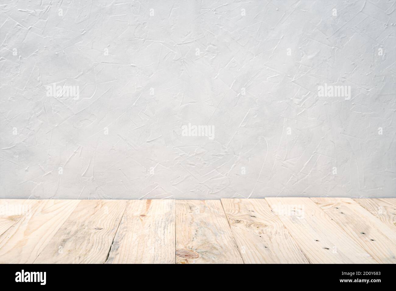 Leerer Holzdecktisch über weißem texturierten Wandhintergrund. Mustervorlage. Speicherplatz kopieren Stockfoto