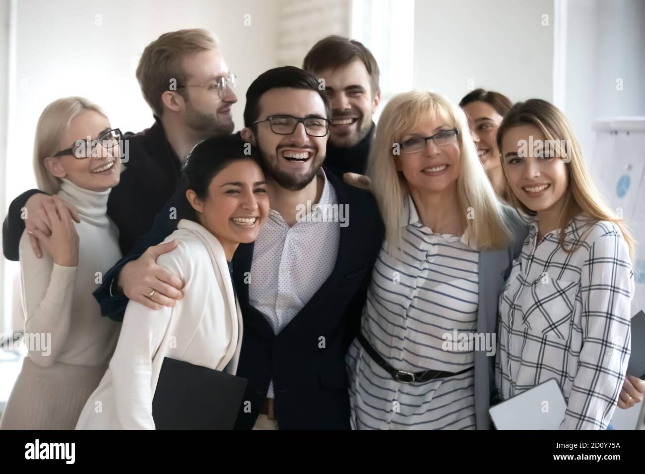 Lächelnde Kollegen zeigen Einheit am Arbeitsplatz Stockfoto