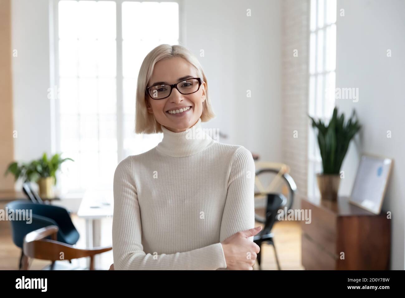 Kopfbild einer lächelnden Mitarbeiterin in einer Brille Stockfoto