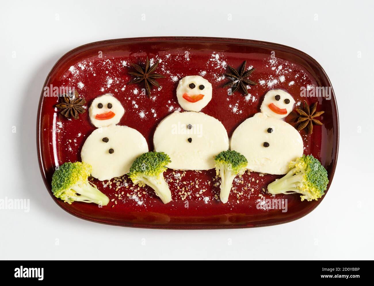 Lustiger Teller mit drei Schneemännern aus Mozzarella und Brokkoli. Frühstücksidee für Kinder. Vegetarisches Essen für Neujahr oder Weihnachtsfeier. Stockfoto