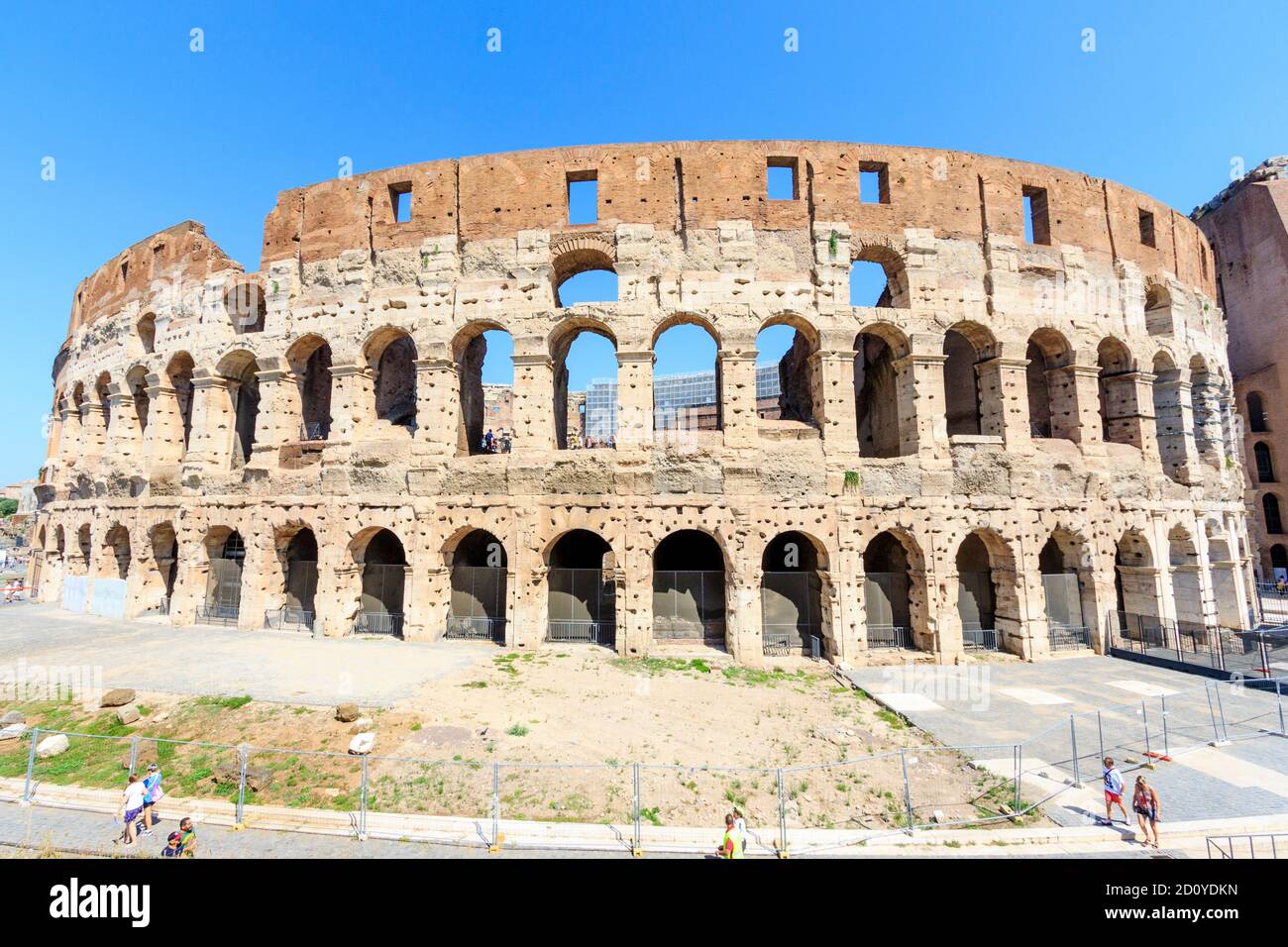 Die Außenfassade des römischen Kolosseums, Flavian Amphitheater, in Rom tagsüber während der heißen Sommerhitze. Blauer Himmel über dem Himmel. Stockfoto