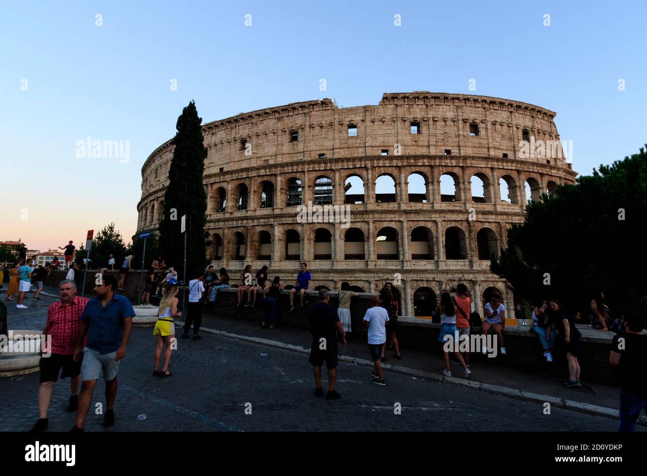 Menschen treffen sich in der Via Nicola Salvi, um die Illuminationen im Inneren des Kolosseums zu erwarten, die während der abendlichen blauen Stunde eingeschaltet werden. Stockfoto