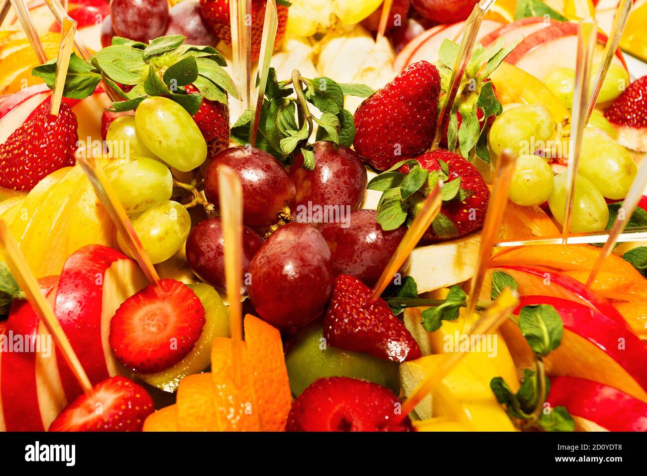 Authentisches Buffet mit verschiedenen frischen Früchten, Beeren und Zitrusfrüchten. Stimmungsvolle Morgenbeleuchtung, modischer, trendiger Spot-Weichfokus. Stockfoto