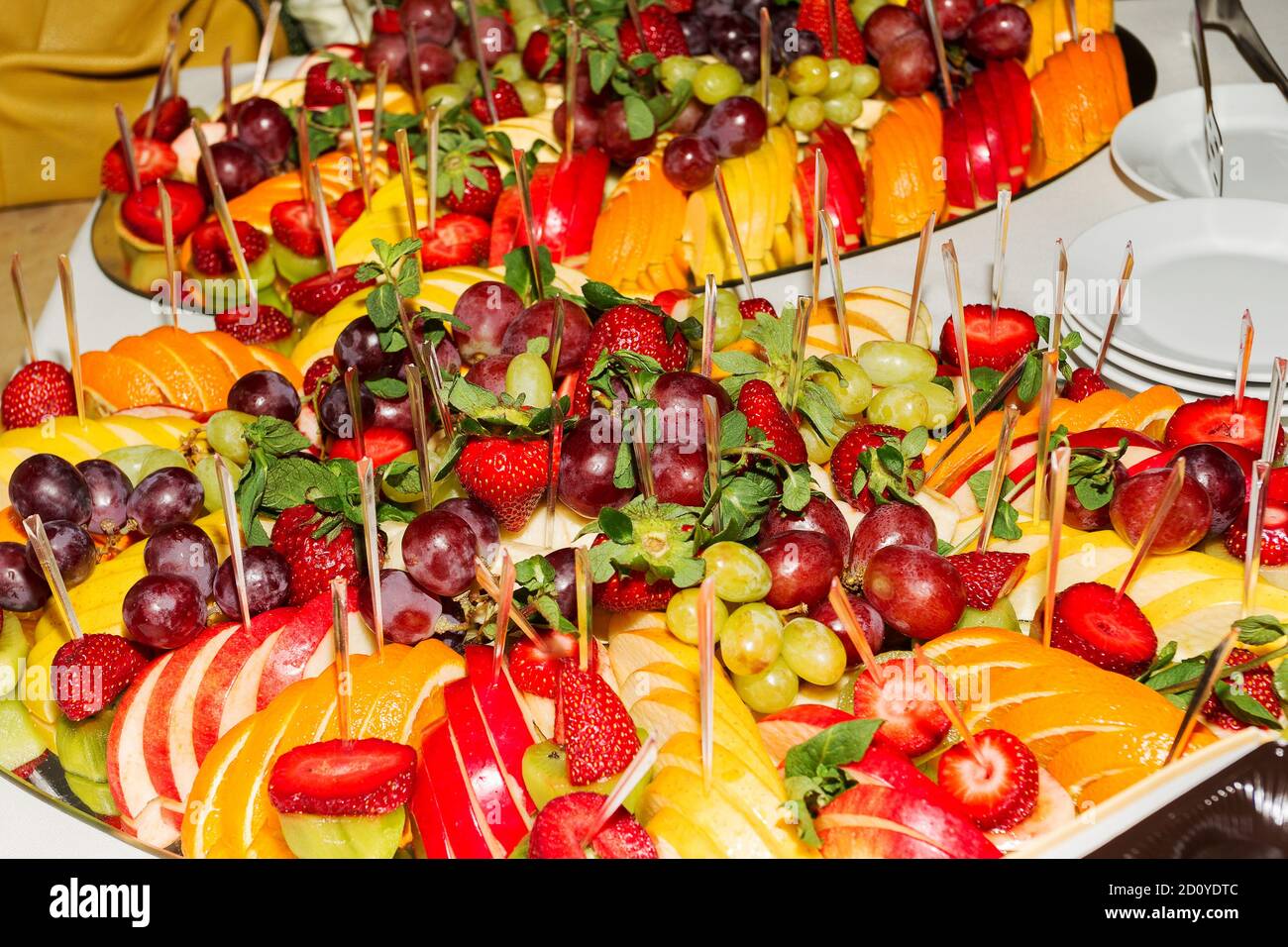 Authentisches Buffet mit verschiedenen frischen Früchten, Beeren und Zitrusfrüchten. Stimmungsvolle Morgenbeleuchtung, modischer, trendiger Spot-Weichfokus. Stockfoto
