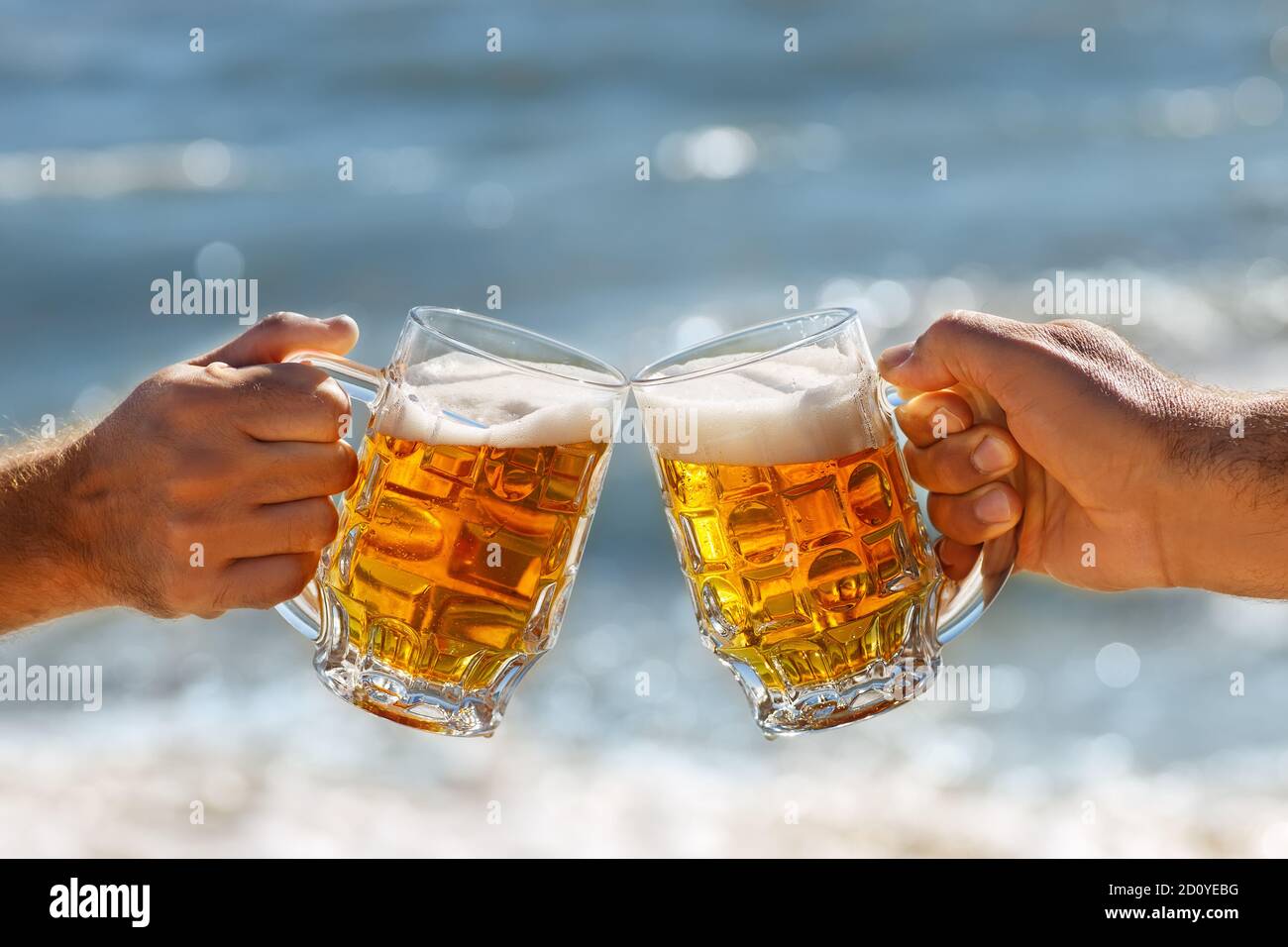 Hände mit einem Becher Bier, das Toast macht Stockfoto