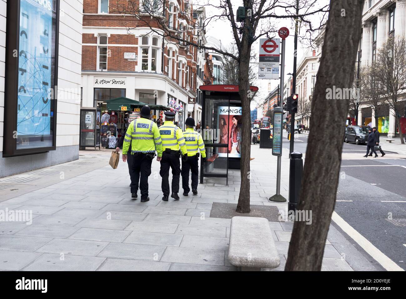 dh Police OXFORD STREET LONDON ENGLAND Großbritannien drei Polizisten auf Schlagen Sie den kleinen, kurzen Polizisten, der mittelgroß ist Stockfoto