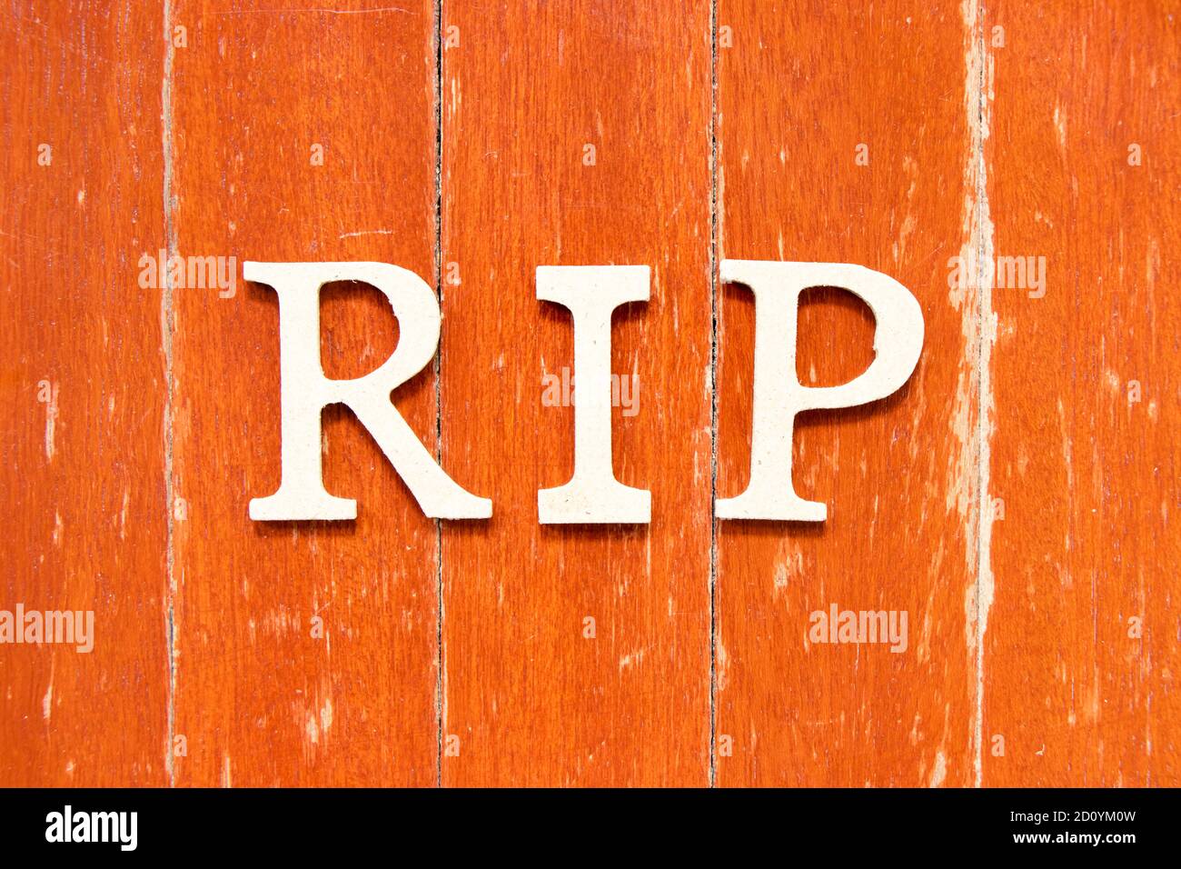 Buchstabe im Wort RIP (Abkürzung für Ruhe in Frieden) Auf alten roten Farbe Holzplatte Hintergrund Stockfoto