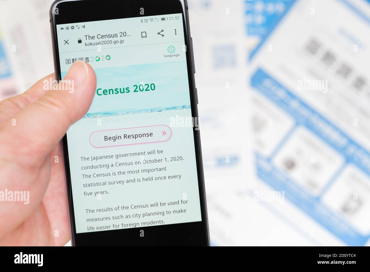 Fuji City, Shizuoka-Ken, Japan - 4. Oktober 2020: Zugriff auf die Website des Japan Census 2020 per Smartphone. Verschwommener Hintergrund mit Formularen und Umschlägen. Stockfoto