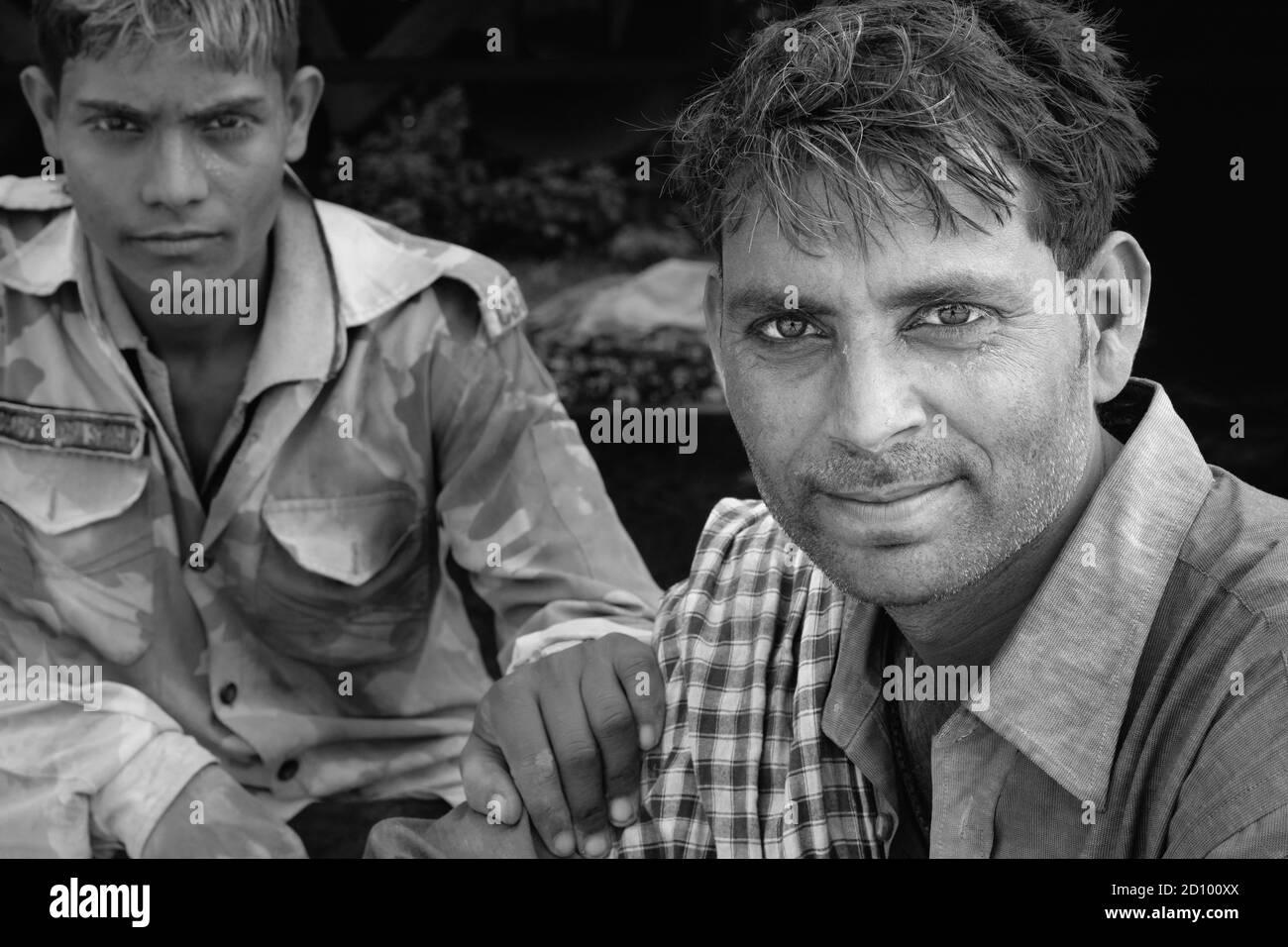 Arbeiter, die mit schweren Zementsäcken beschäftigt sind, genießen eine Pause neben der Eisenbahn in Mathura, Uttar Pradesh, Indien. Stockfoto