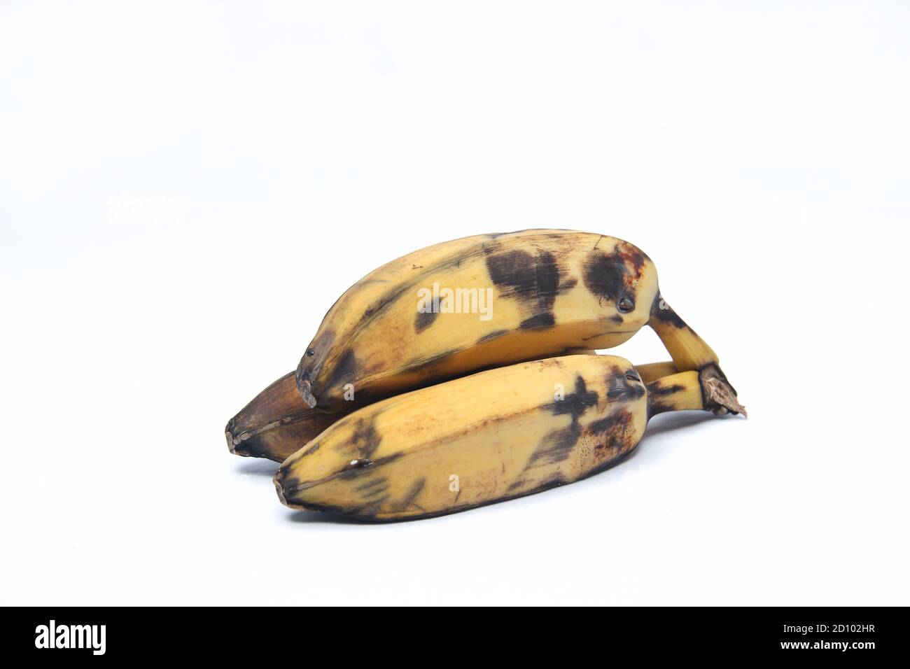 Reife Banane mit schwarzen Flecken auf der Haut. Alte Banane isoliert auf weißem Hintergrund Stockfoto