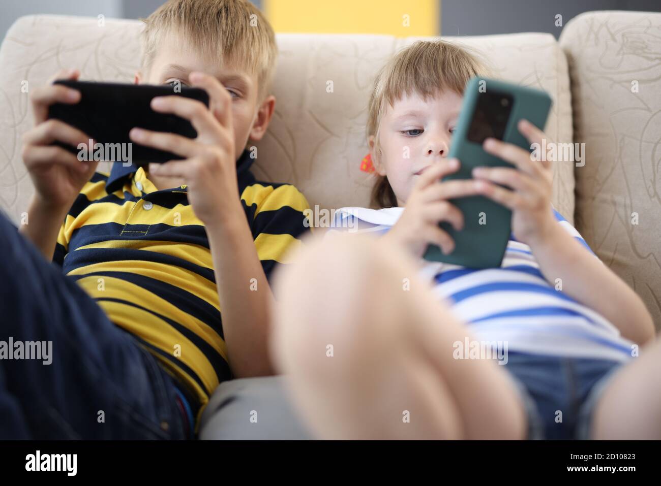 Kinder halten das mobile Gerät in den Händen und spielen. Stockfoto