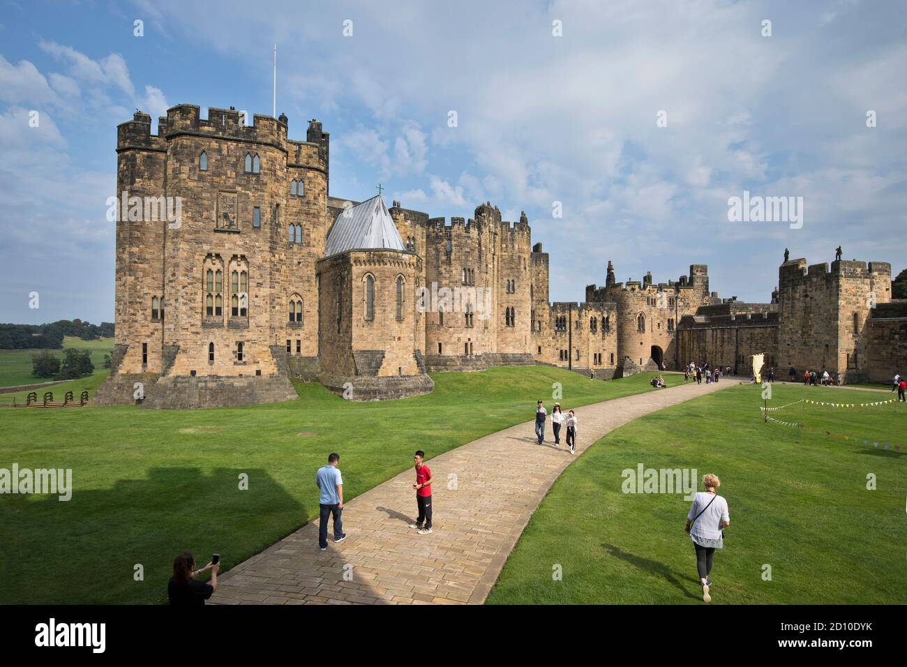 Touristen, die die äußere Bailey von Alnwick Castle in Northumberland erkunden, ein wichtiger Ort für Hogwarts in den Harry Potter Filmen. Stockfoto