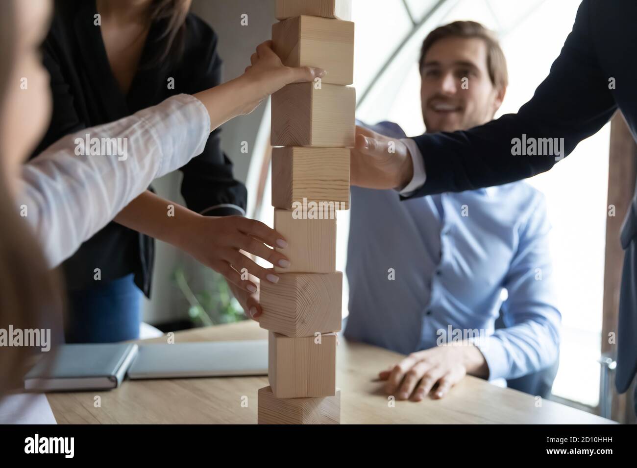 Nahaufnahme Fokus auf Holzblöcke Turm, von glücklichen Teamkollegen gebaut. Stockfoto