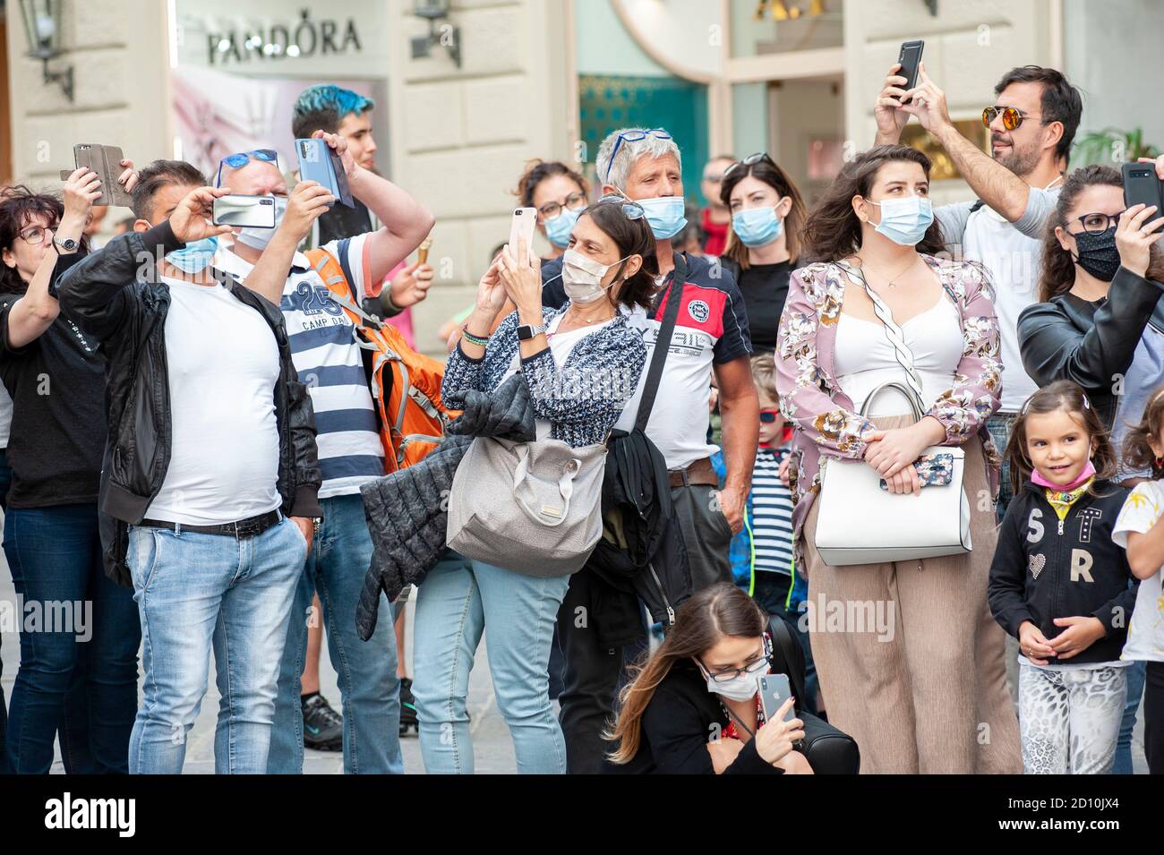 Florenz, Italien - 2020. September 26: Touristen (nicht identifizierte Personen) tragen Gesichtsmasken und fotografieren mit dem Telefon auf der Straße, während Coronavirus. Stockfoto