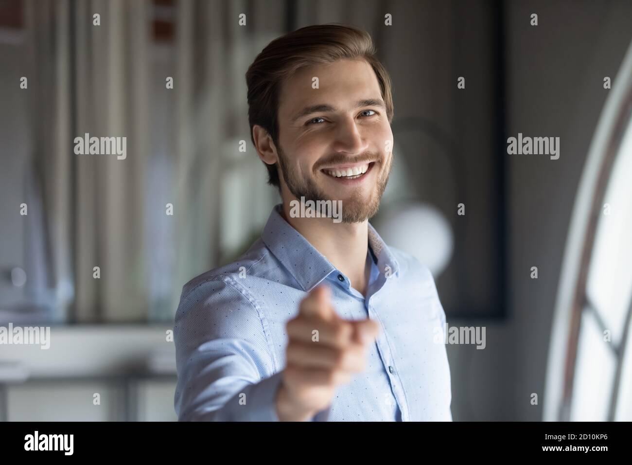 Lächelnd jung hübsch männlich hr Manager zeigt feiner auf Kamera. Stockfoto