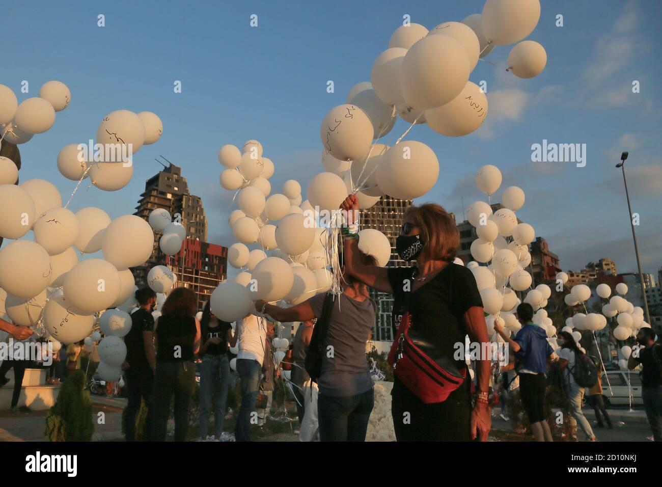 Beirut, Libanon. Oktober 2020. Libanesische Menschen lassen bei einer Zeremonie anlässlich des zweimonatigen Jahrestages der Explosion, bei der 200 Menschen ums Leben kamen und mehr als 6,500 weitere verletzt wurden, Ballons frei, die die Namen der Opfer der Explosion am 04. August 2020 in Beirut tragen. Quelle: Marwan Naamani/dpa/Alamy Live News Stockfoto