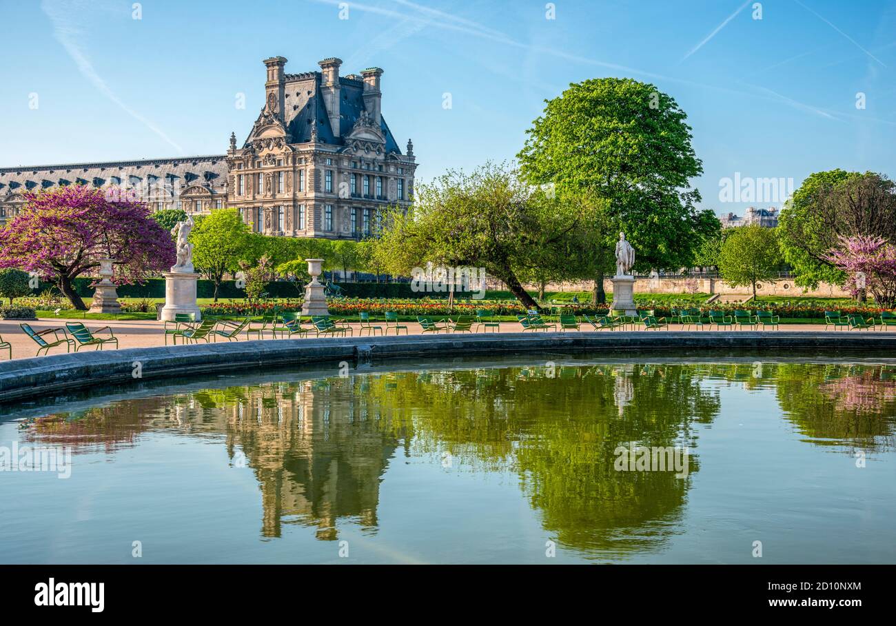 Panoramablick auf den Tuileries Park und den Louvre mit Blumen, Statuen, Brunnen und Kirschblüten im April - Frühling in Paris, Frankreich. Stockfoto