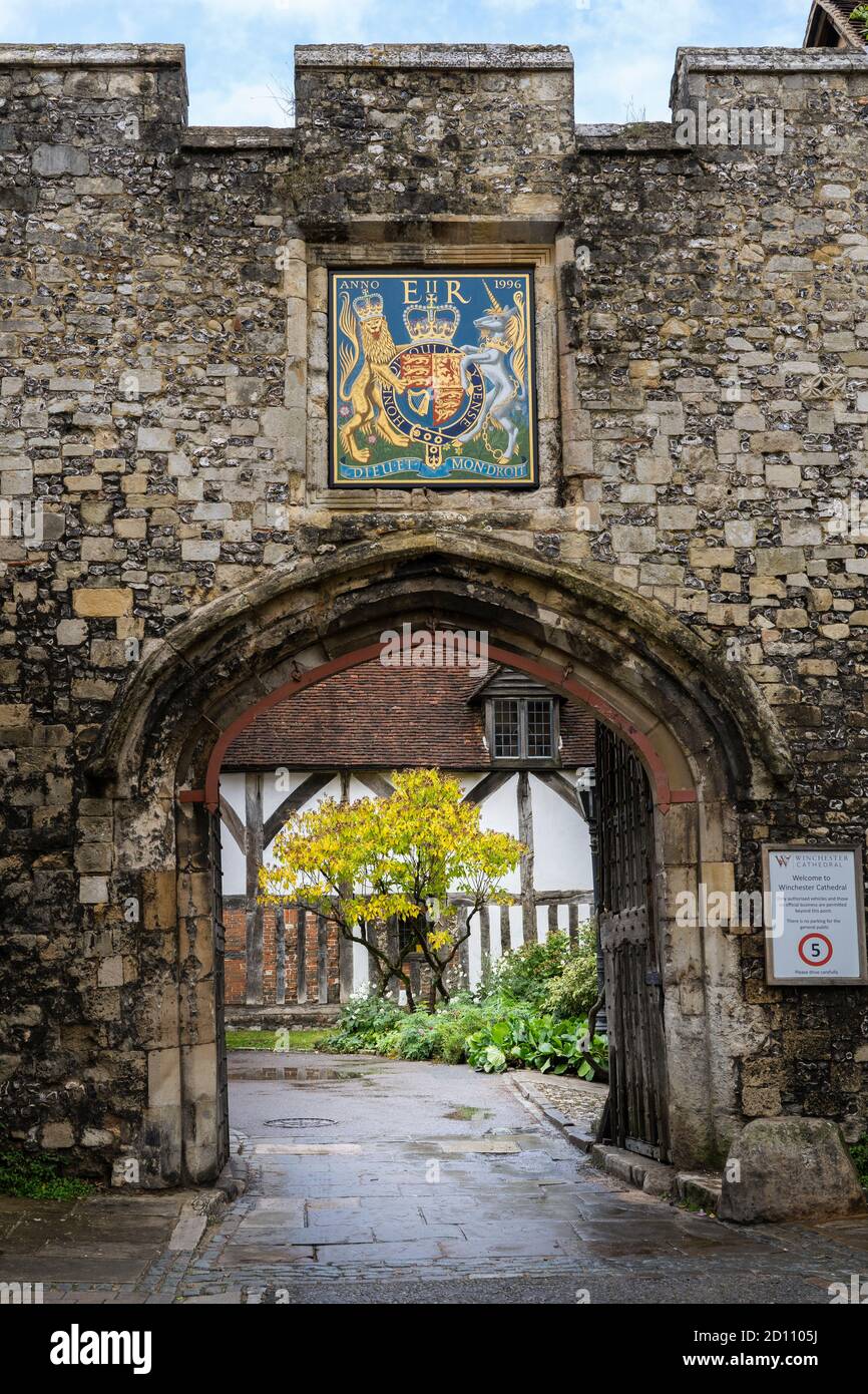 Das Prioratentor im Herbst und das königliche Wappen, ein Steingewölbe aus dem 15. Jahrhundert mit zwei großen eisernen Eichentoren, Cathedral Close, Winchester, Großbritannien Stockfoto