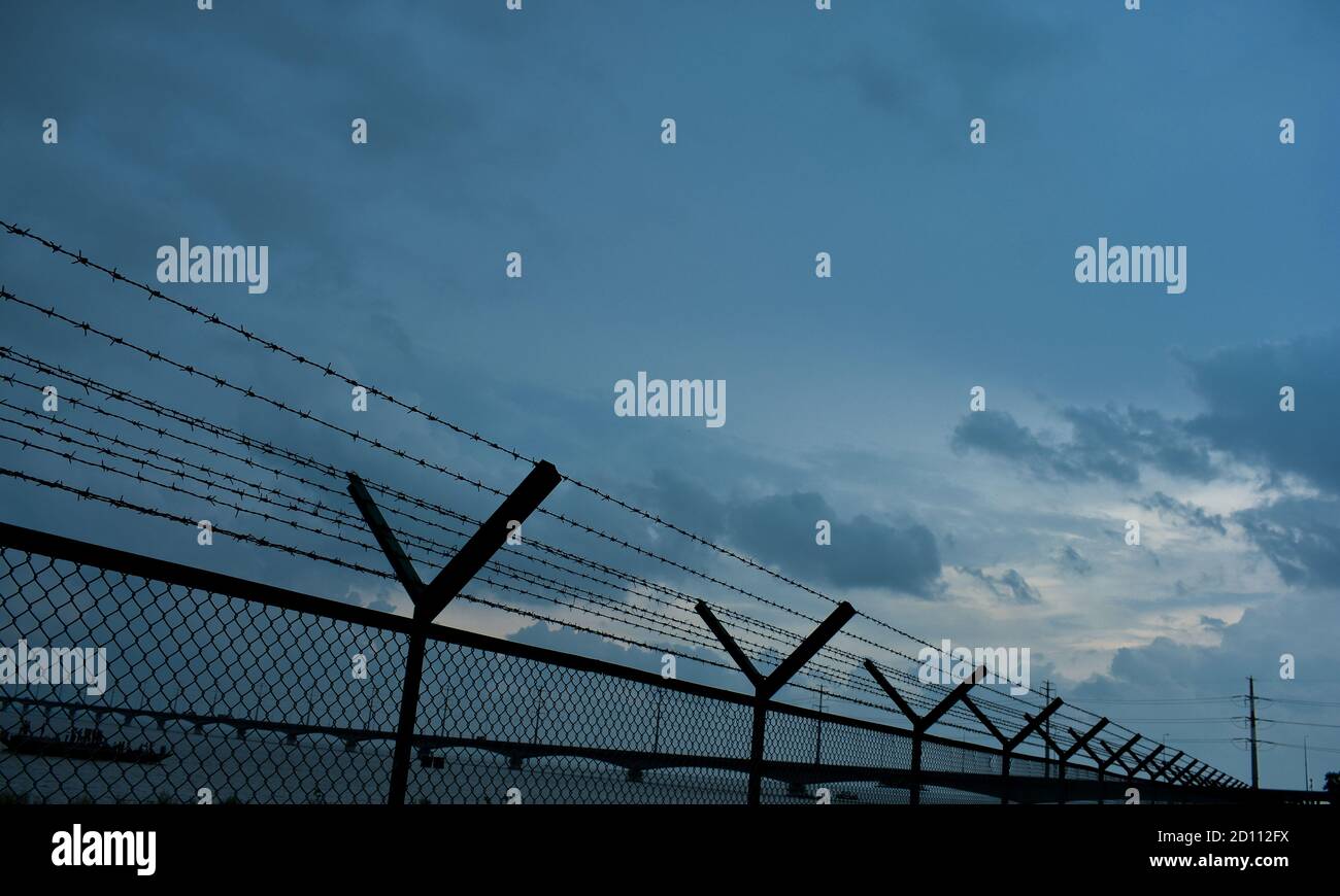 Stacheldraht oder Grenze der USA zum Schutz der Ein Land am Ende eines Landes oder Flusses Ufer mit einem bewölkten Himmel Stockfoto