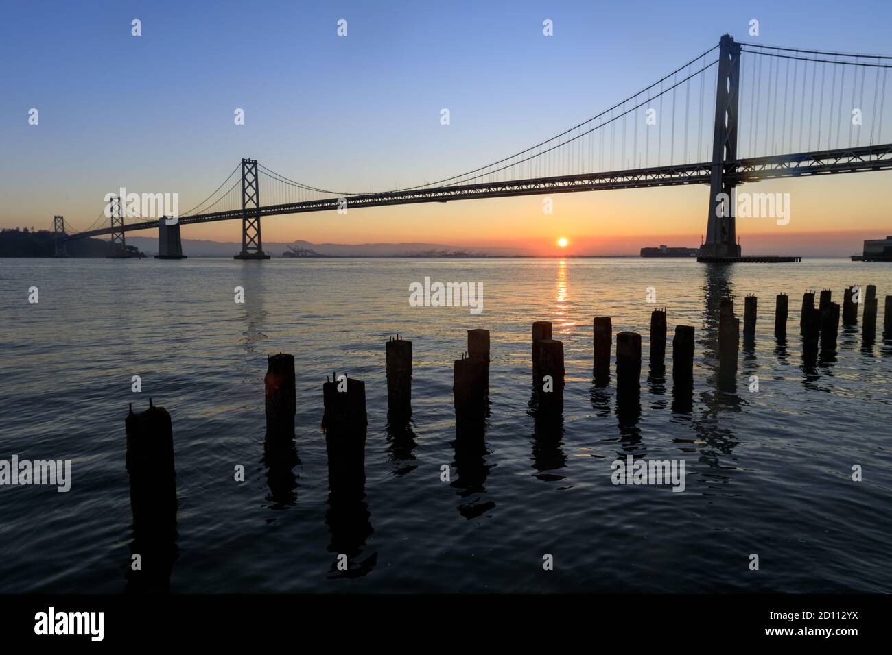 Die Sonne geht über der Bay Bridge auf Stockfoto