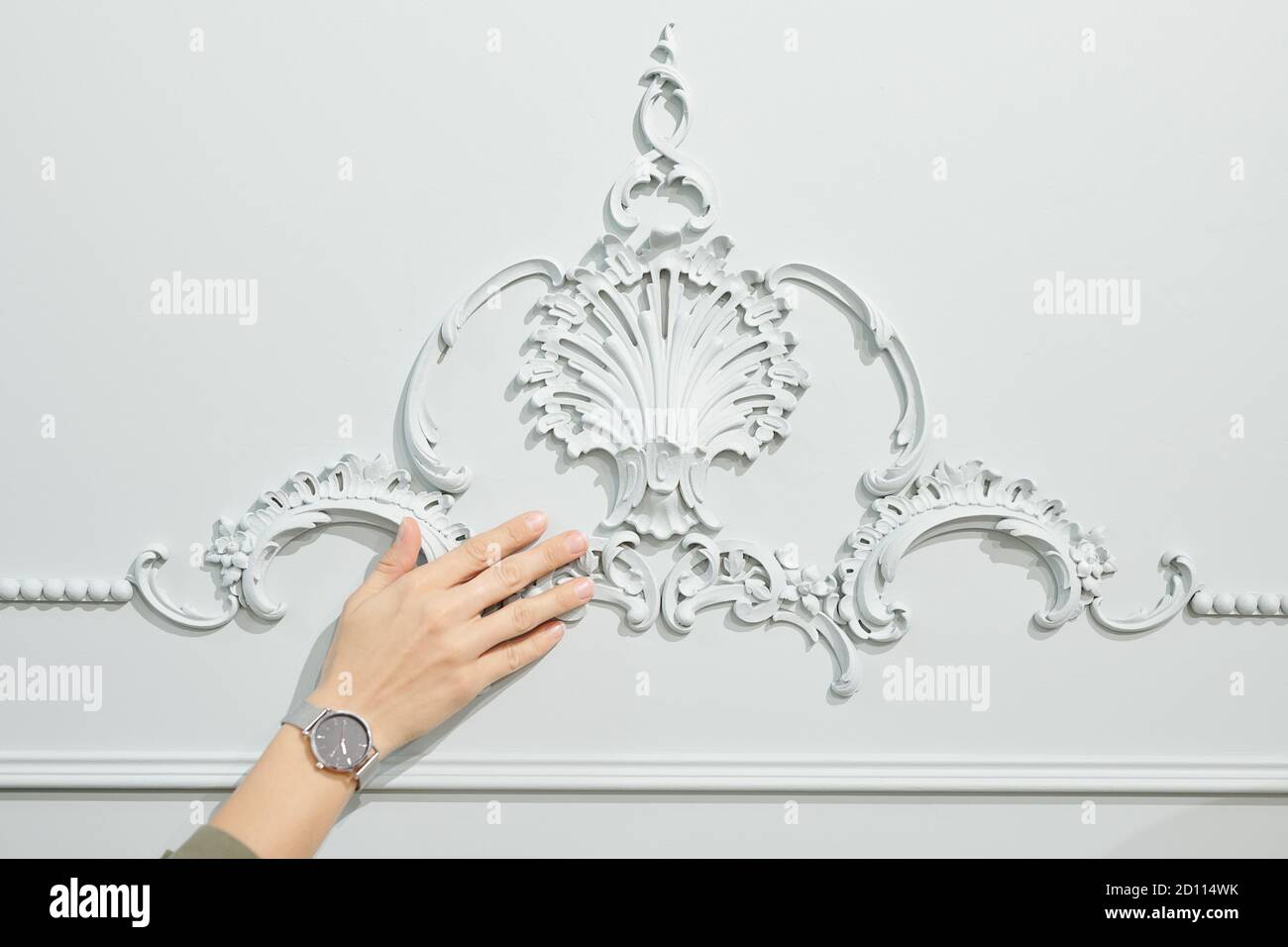 Hand des weiblichen Kunden des Studios der Innenarchitektur berühren Ornament an der Wand Stockfoto