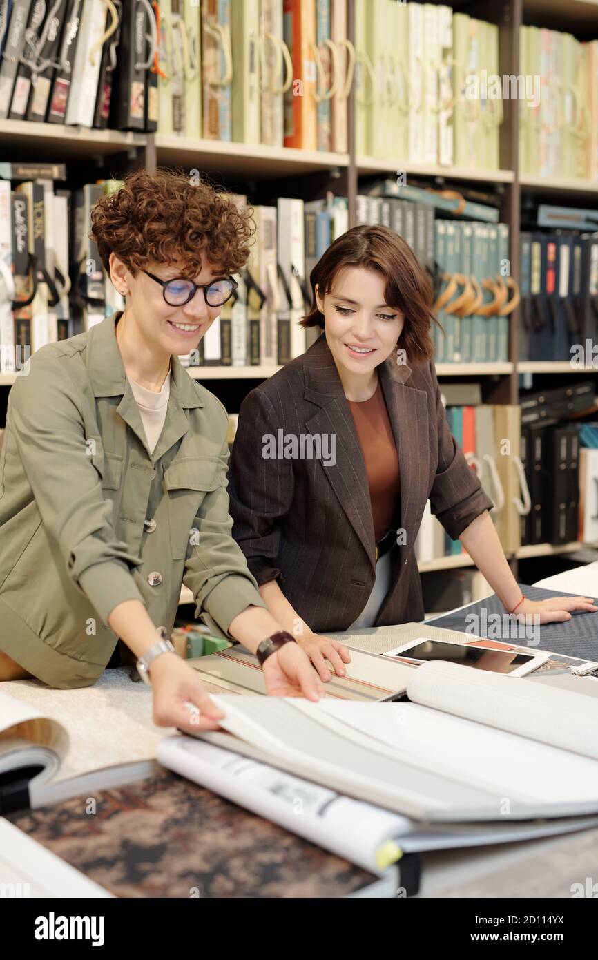 Junge Brünette weibliche Shop-Assistent hilft Kunden, neue zu wählen Hintergrundbilder Stockfoto