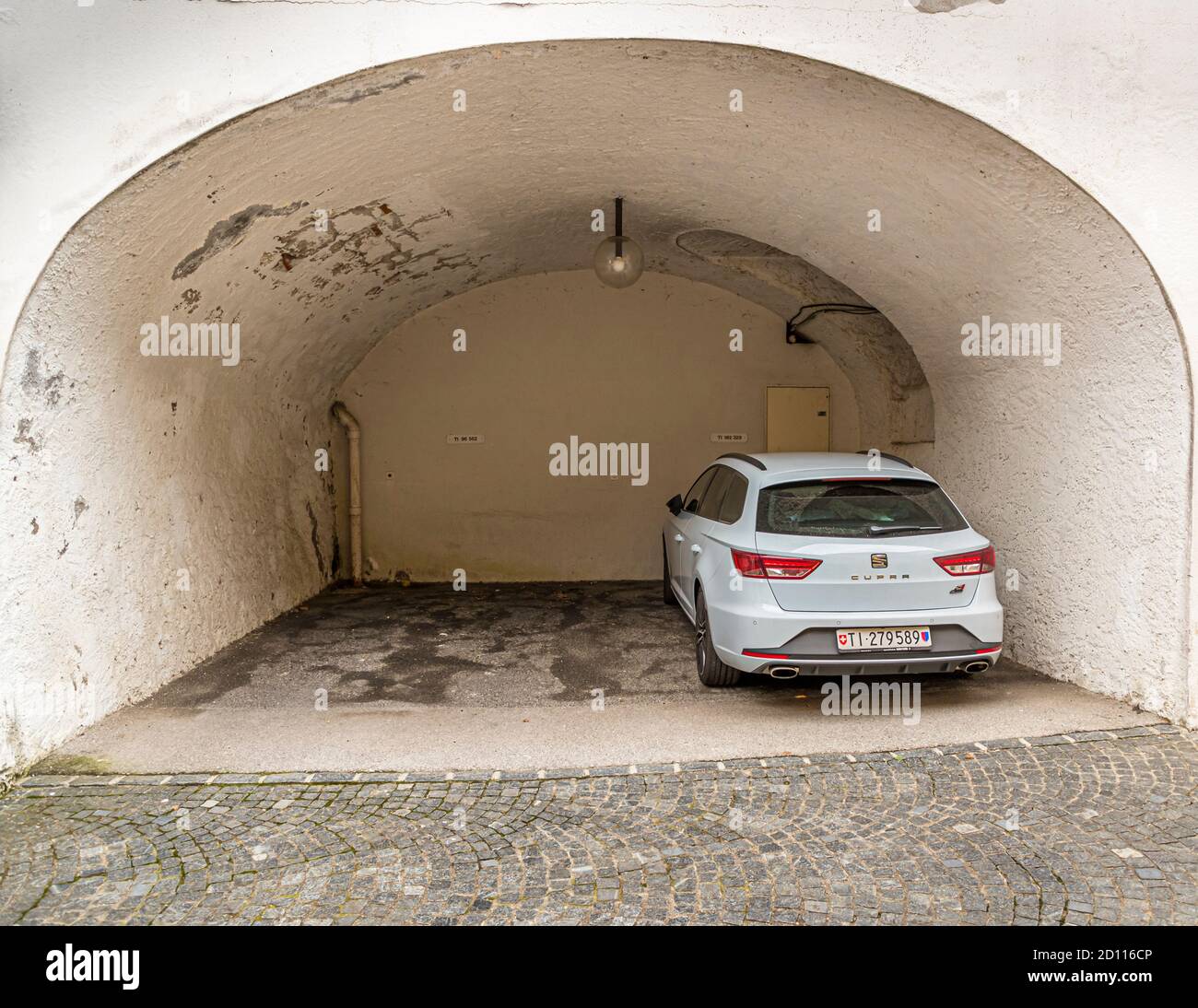 Ein Auto wird in einer umgebauten ehemaligen Kantine von Melide geparkt, wo die Lebensmittel ursprünglich gekühlt gelagert wurden. Kulinarische Tour auf dem Luganersee im Tessin, Circolo di Carona, Schweiz Stockfoto