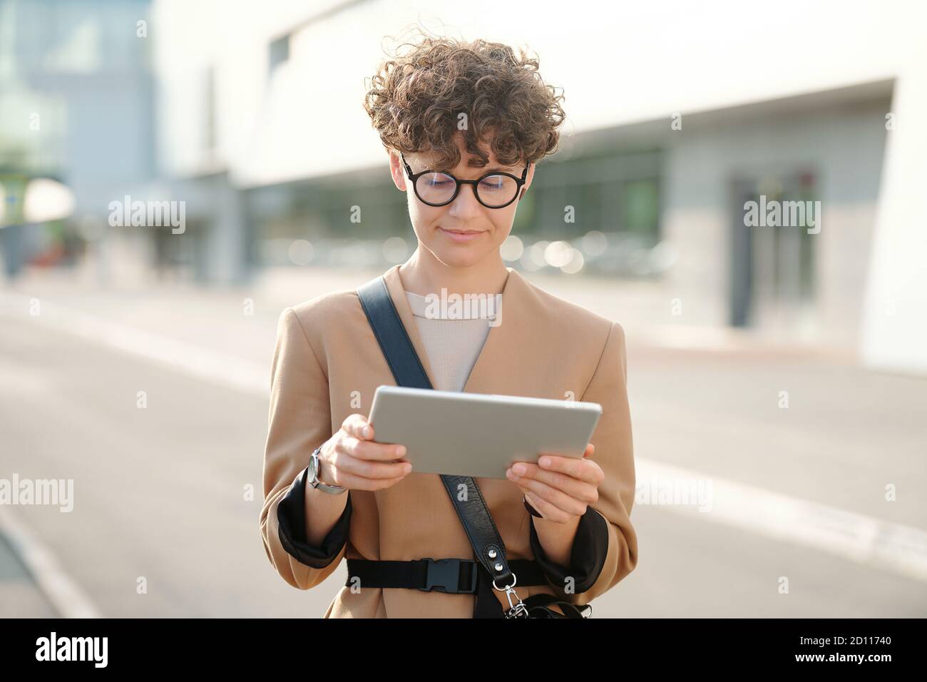 Junge hübsche Brünette Geschäftsfrau mit Tablet beobachten Geschäft Webinar Stockfoto