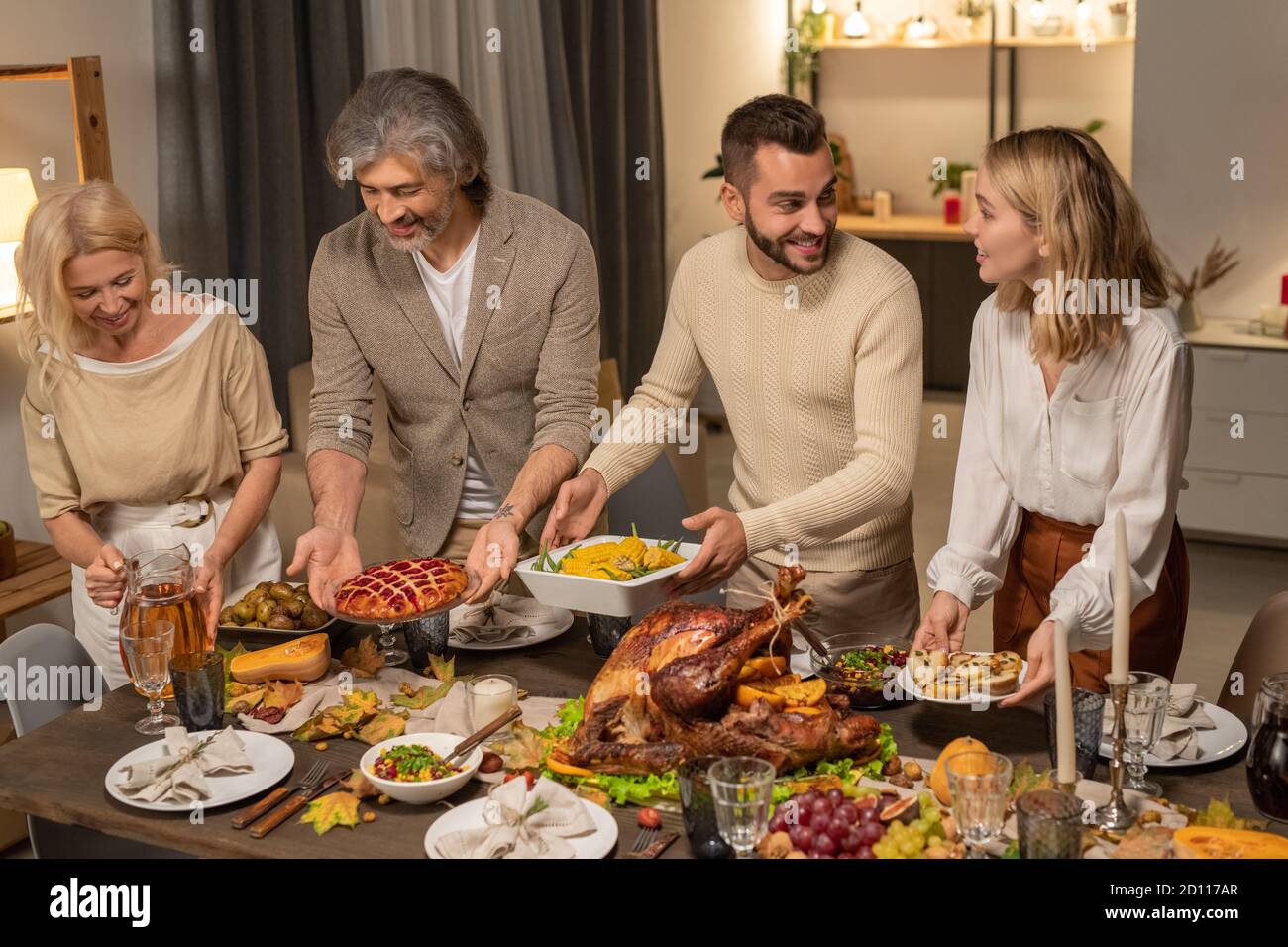 Vier Mitglieder der großen Familie Putting hausgemachtes Essen auf den Tisch Vor der Feier Stockfoto