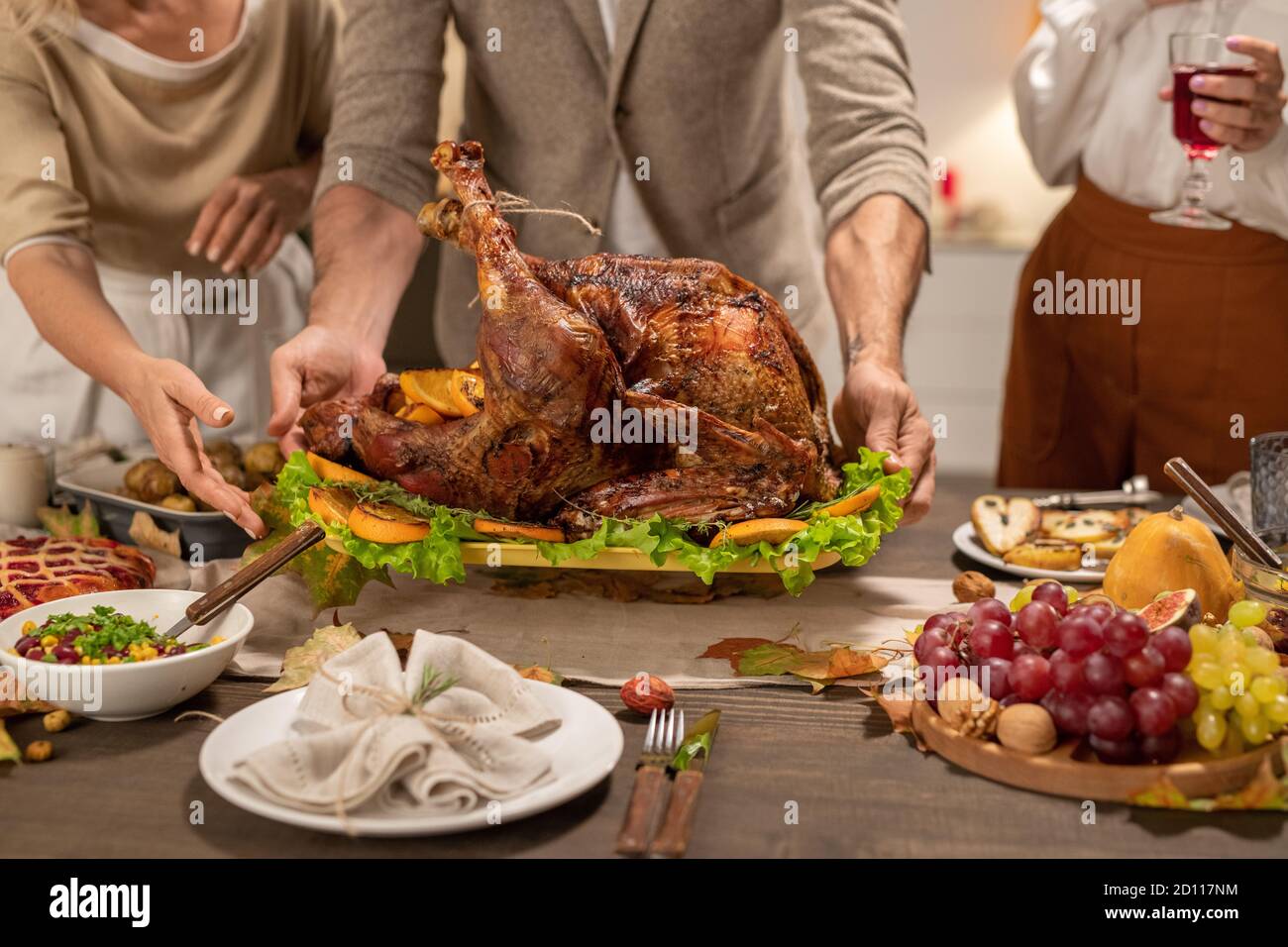 Hände von reifen Mann Putting Tablett mit großen gerösteten hausgemachte türkei auf dem Tisch Stockfoto